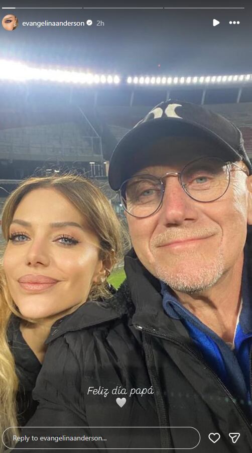 Evangelina Anderson y su padre posanso juntos en un selfie tomado durante un evento nocturno en un estadio iluminado