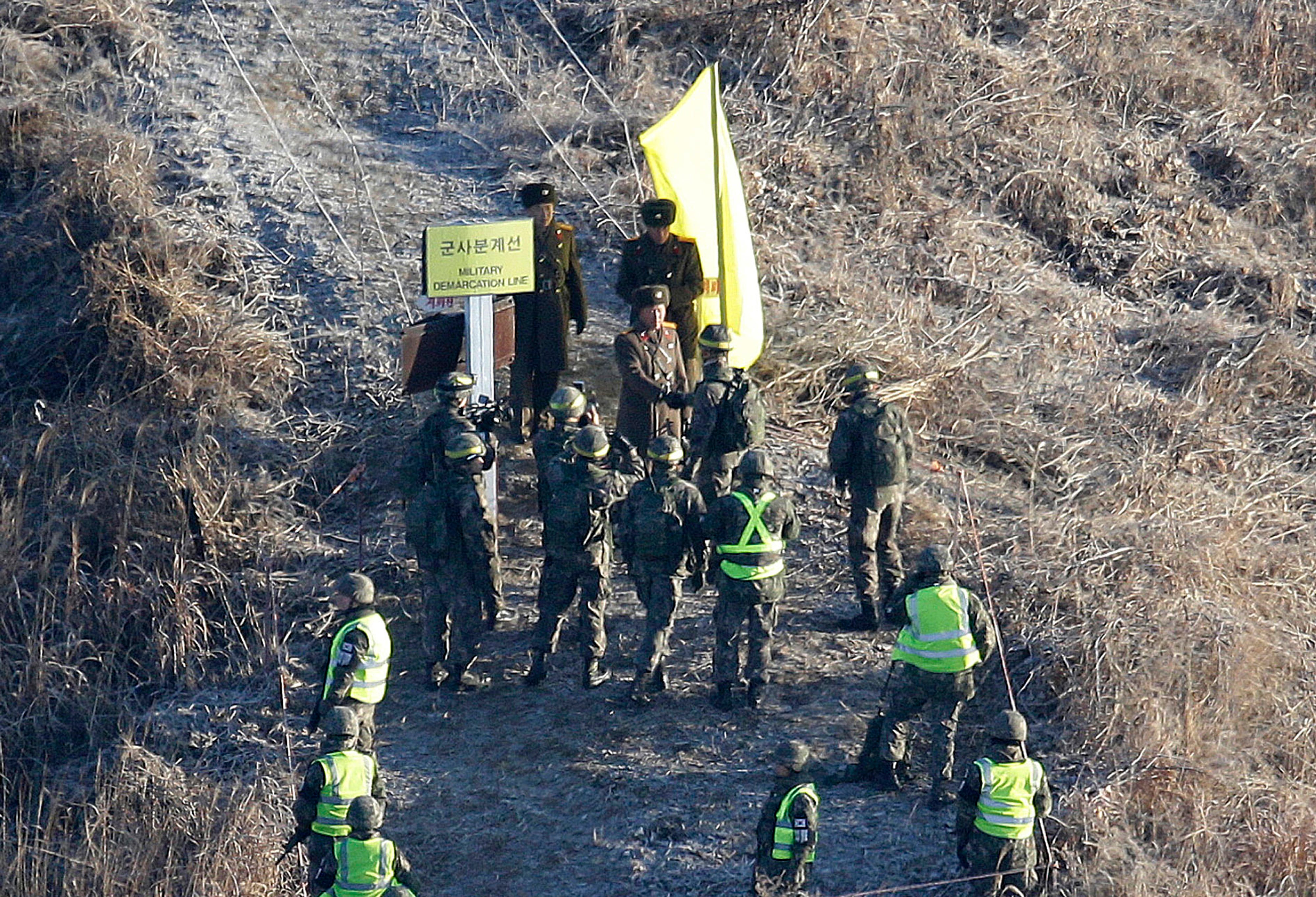 ARCHIVO - Un soldado surcoreano, en el centro abajo, estrecha la mano de un soldado norcoreano antes de cruzar la Línea de Demarcación Militar dentro de la Zona Desmilitarizada (DMZ) para inspeccionar un puesto de guardia norcoreano desmantelado en la zona central de la frontera entre las dos coreas en Cheorwon, el 12 de diciembre de 2018 (AP /Ahn Young-joon)