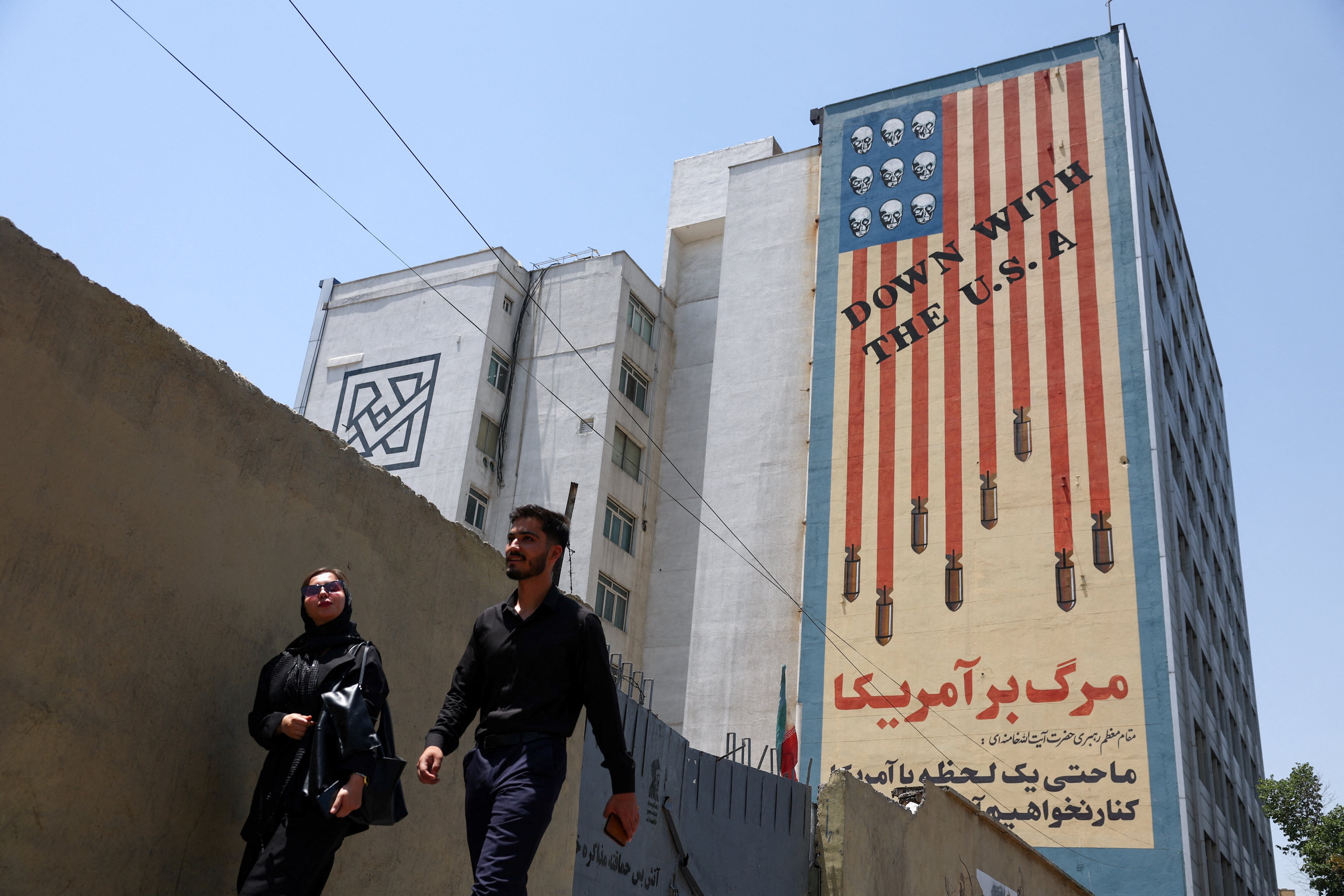 Varias personas caminan junto a un mural contra Estados Unidos en Teherán, Irán (REUTERS)