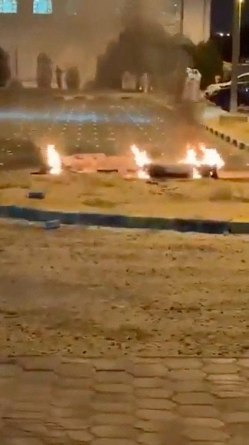 En esta captura de pantalla obtenida de un vídeo de redes sociales, se observan escombros ardiendo en el suelo de un aparcamiento tras los informes de ataques con misiles y drones en Sabah Al Nasser, Kuwait, el 3 de junio de 2026 (REUTERS)