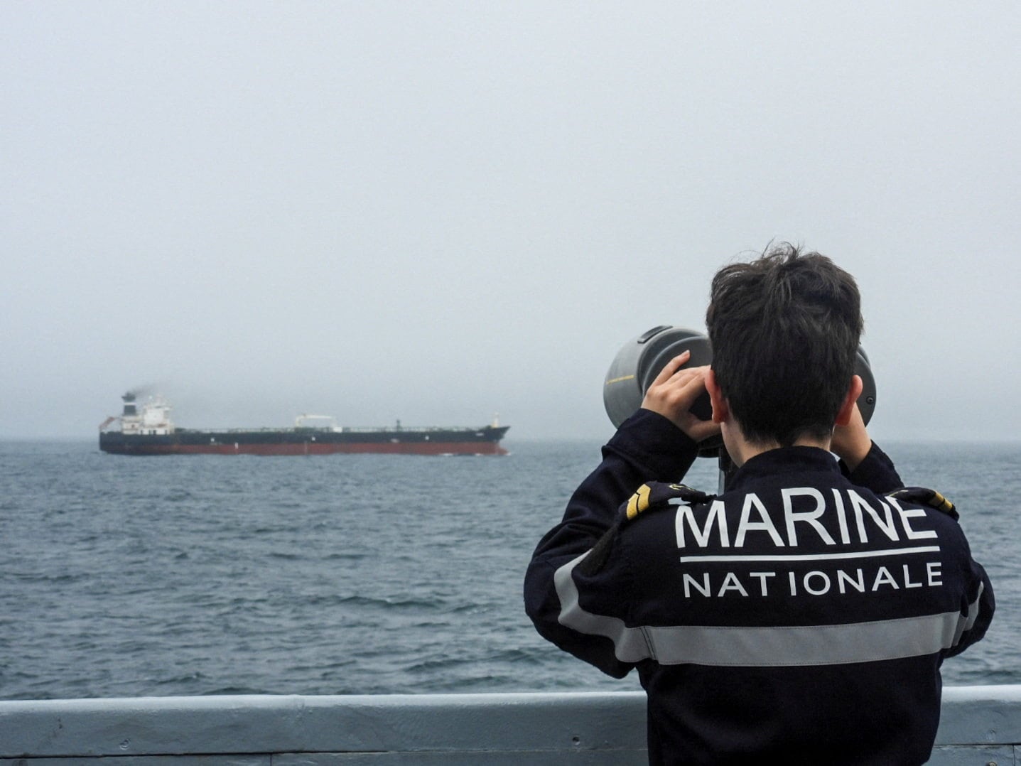 Un integrante de la Armada francesa observa el petrolero Tagor, sujeto a sanciones internacionales, navegando en el Atlántico el domingo. El buque partió desde Murmansk enarbolando falsamente pabellón camerunés. (Marine Nationale/Reuters)