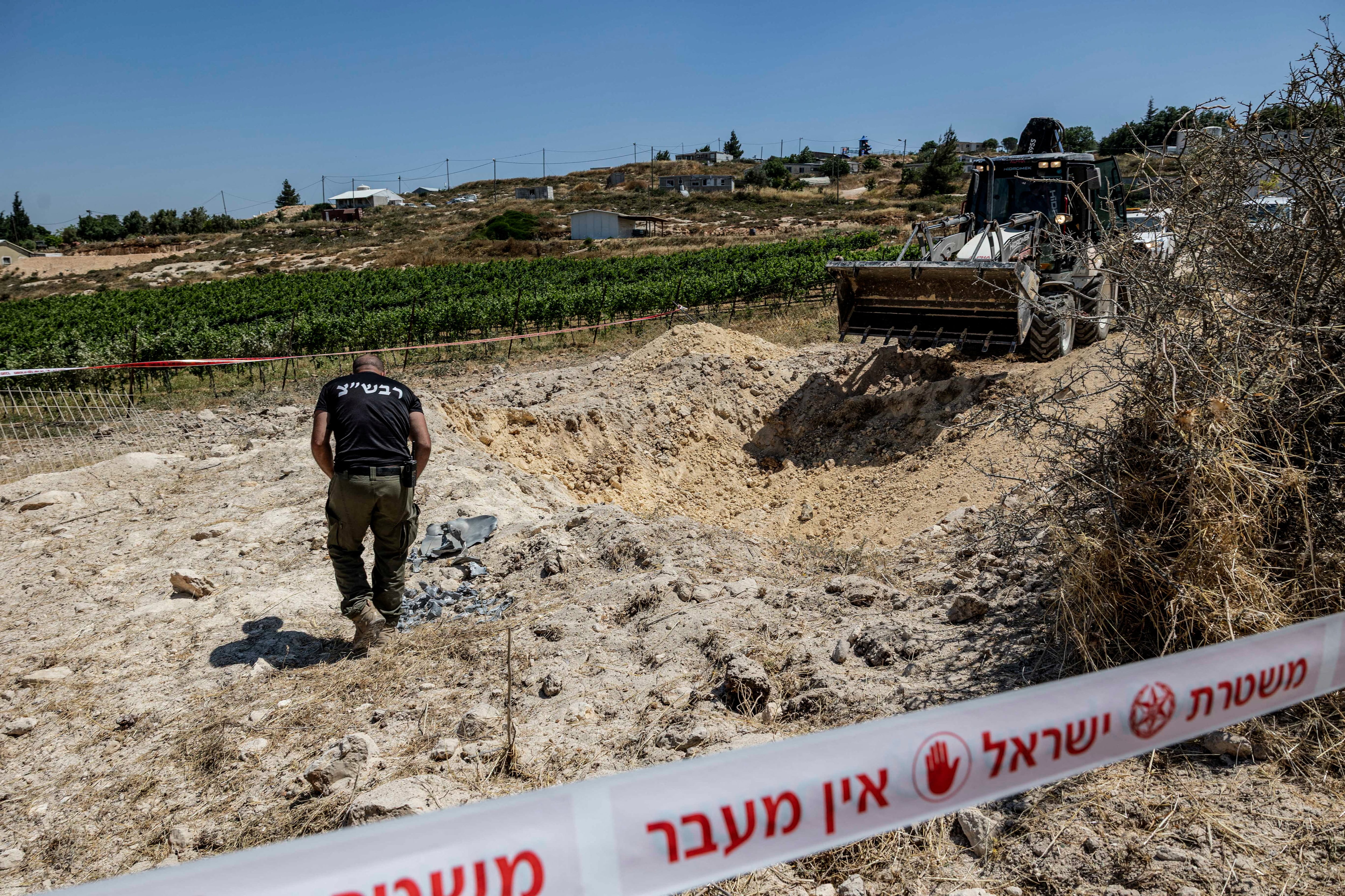 Un miembro del personal de seguridad israelí inspecciona un lugar de impacto, después de que Irán lanzara misiles hacia Israel, en un asentamiento israelí en la Cisjordania ocupada por Israel, 8 de junio de 2026. REUTERS/Naama Stern
