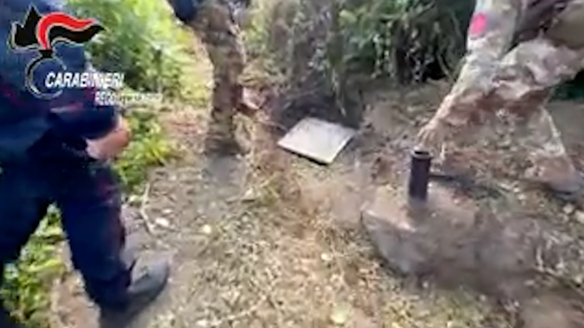 Agentes de los Carabinieri inspeccionan la rejilla de acceso al túnel de escape del búnker de la 'Ndrangheta descubierto en Ardore, Calabria. (Carabinieri)