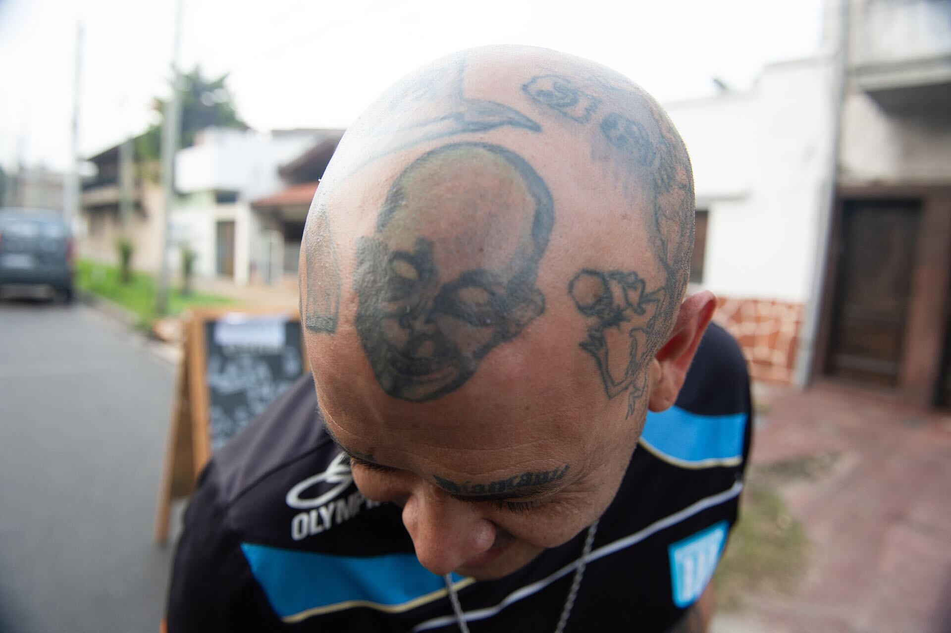 Durante el velorio, un devoto seguidor muestra los elaborados tatuajes que cubren su cabeza como parte de su homenaje al artista
