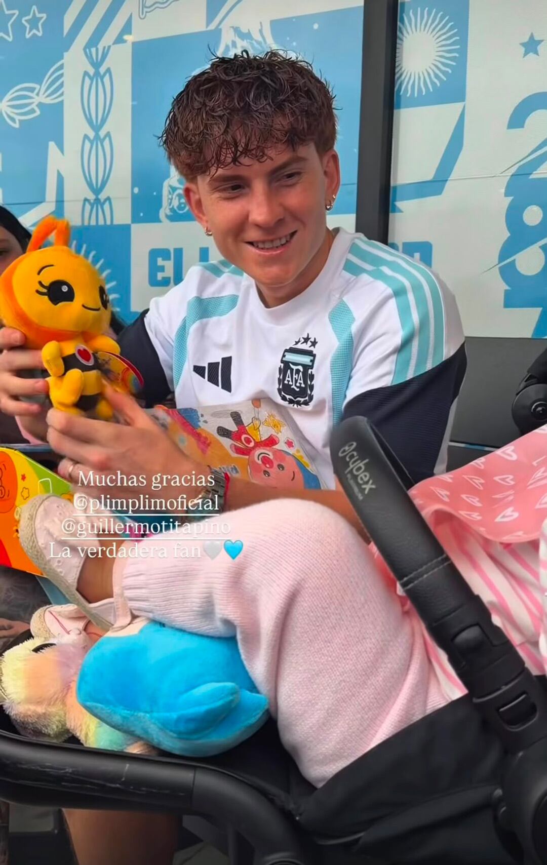 El futbolista El Colo Barco sonríe mientras sostiene un muñeco de Abejita Chiquitita junto a su hija Gemma en la concentración de la Selección argentina.