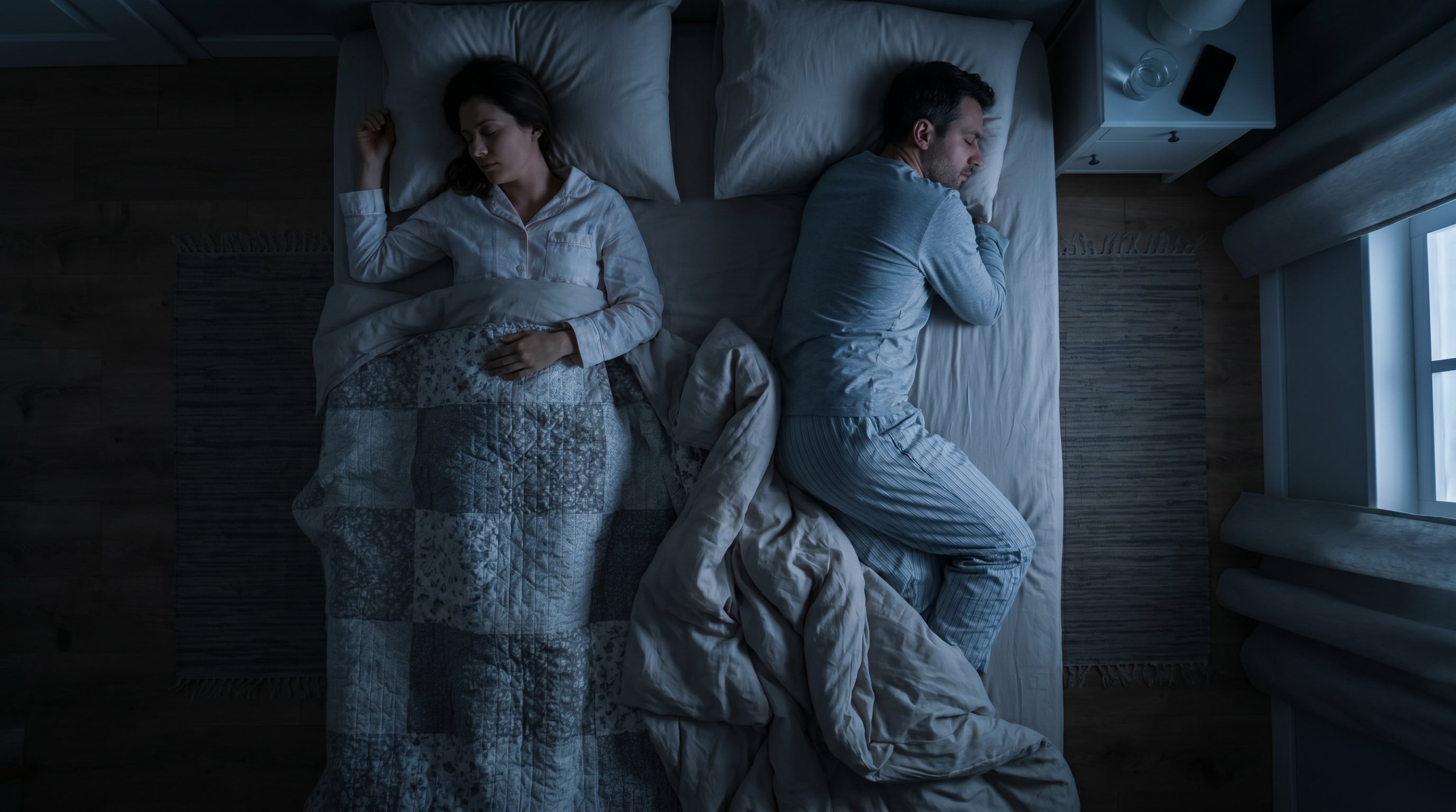 Una mujer y un hombre duermen profundamente en una cama de dos plazas durante la noche, ella boca arriba y él boca abajo, ambos con pijama y cubiertos. (Imagen Ilustrativa Infobae)