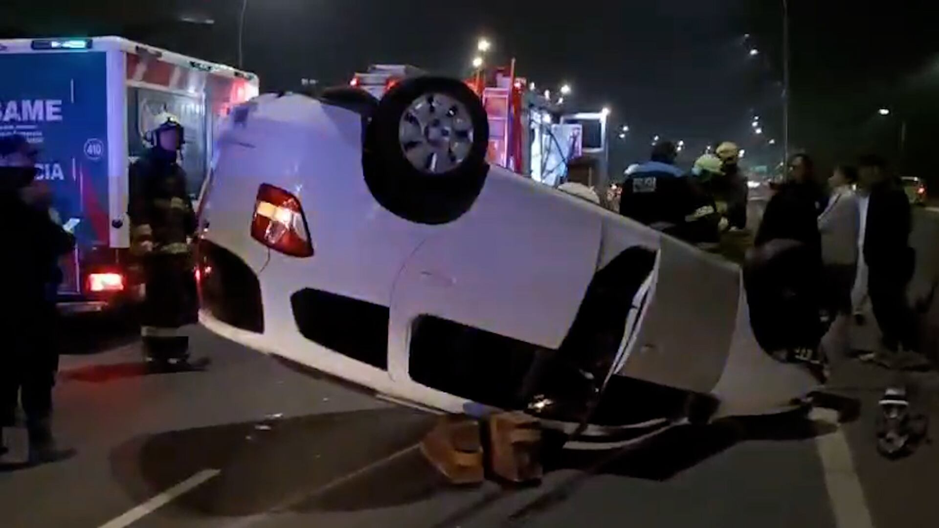 Un vehículo blanco aparece volcado sobre la calzada de la General Paz, mientras personal de emergencias trabaja en el lugar durante la noche del 28 de junio de 2026.