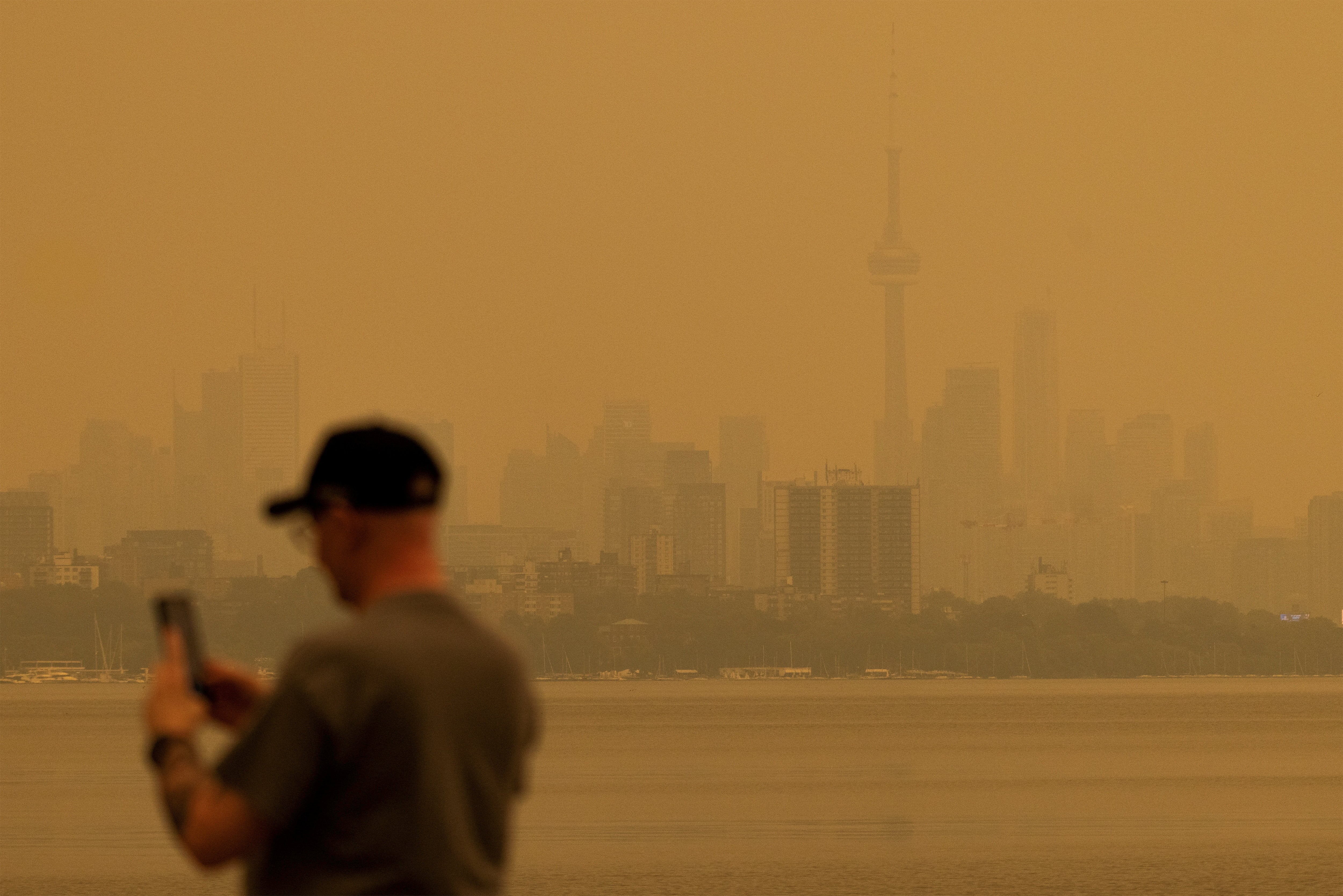 Una persona fotografía el paisaje mientras el humo de los incendios forestales envuelve Toronto y deteriora la calidad del aire (REUTERS/Carlos Osorio)