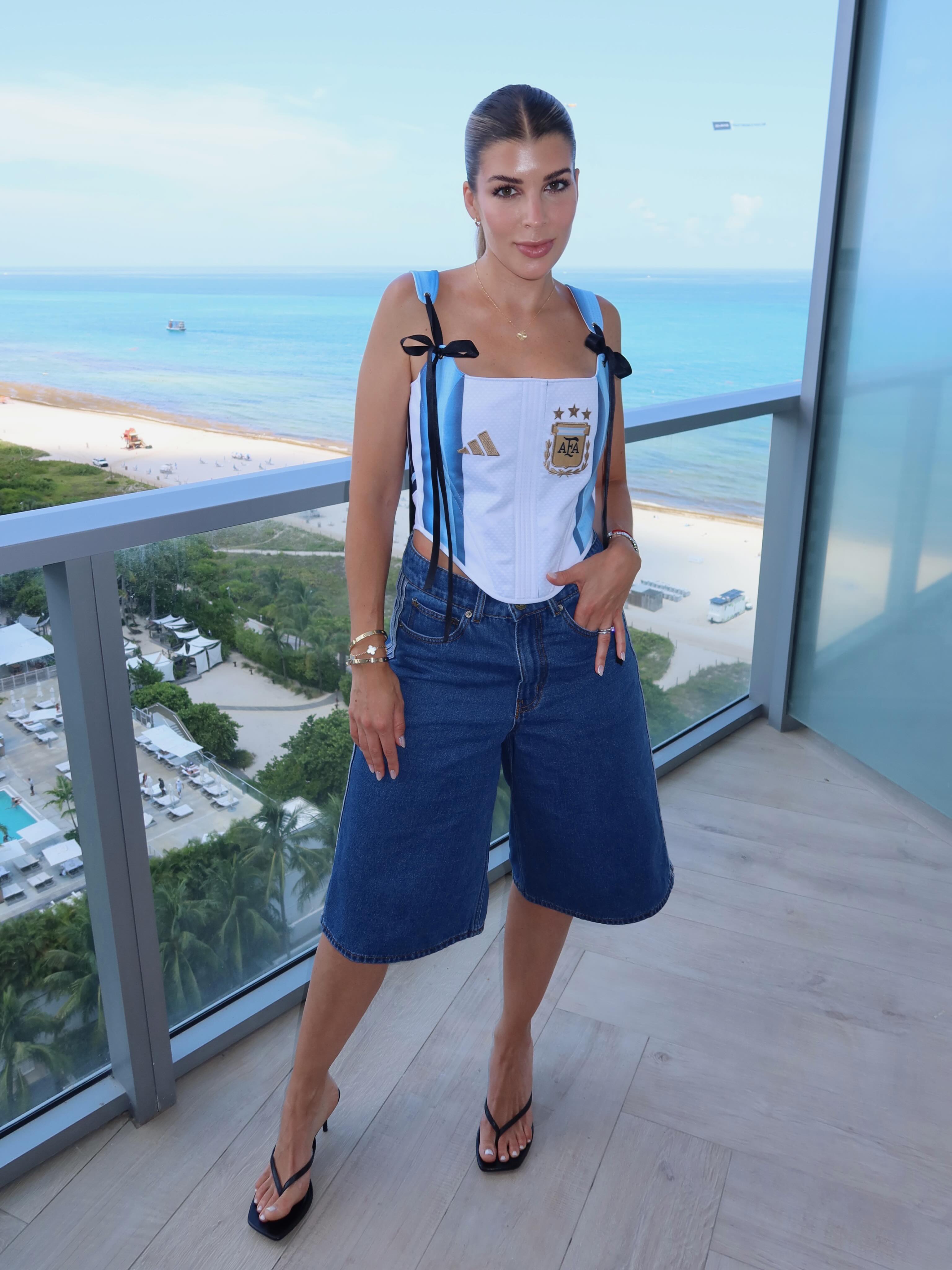 Rocío Espósito posa en un balcón con vista a la playa y el mar, luciendo un corset con los colores y el escudo de la selección argentina.