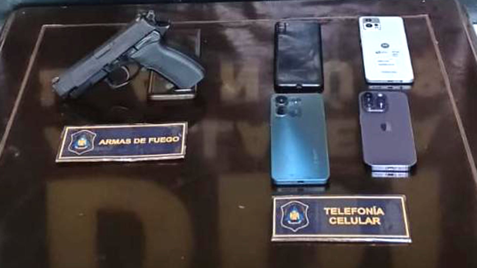 Los cuatro teléfonos celulares y la réplica de arma de fuego que le secuestraron al sospechoso.