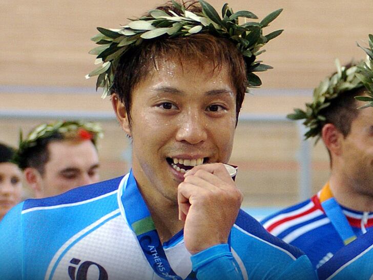 El ciclista japonés Toshiaki Fushimi celebra con su medalla, portando una corona de laurel durante los Juegos Olímpicos de Atenas 2004 (X)
