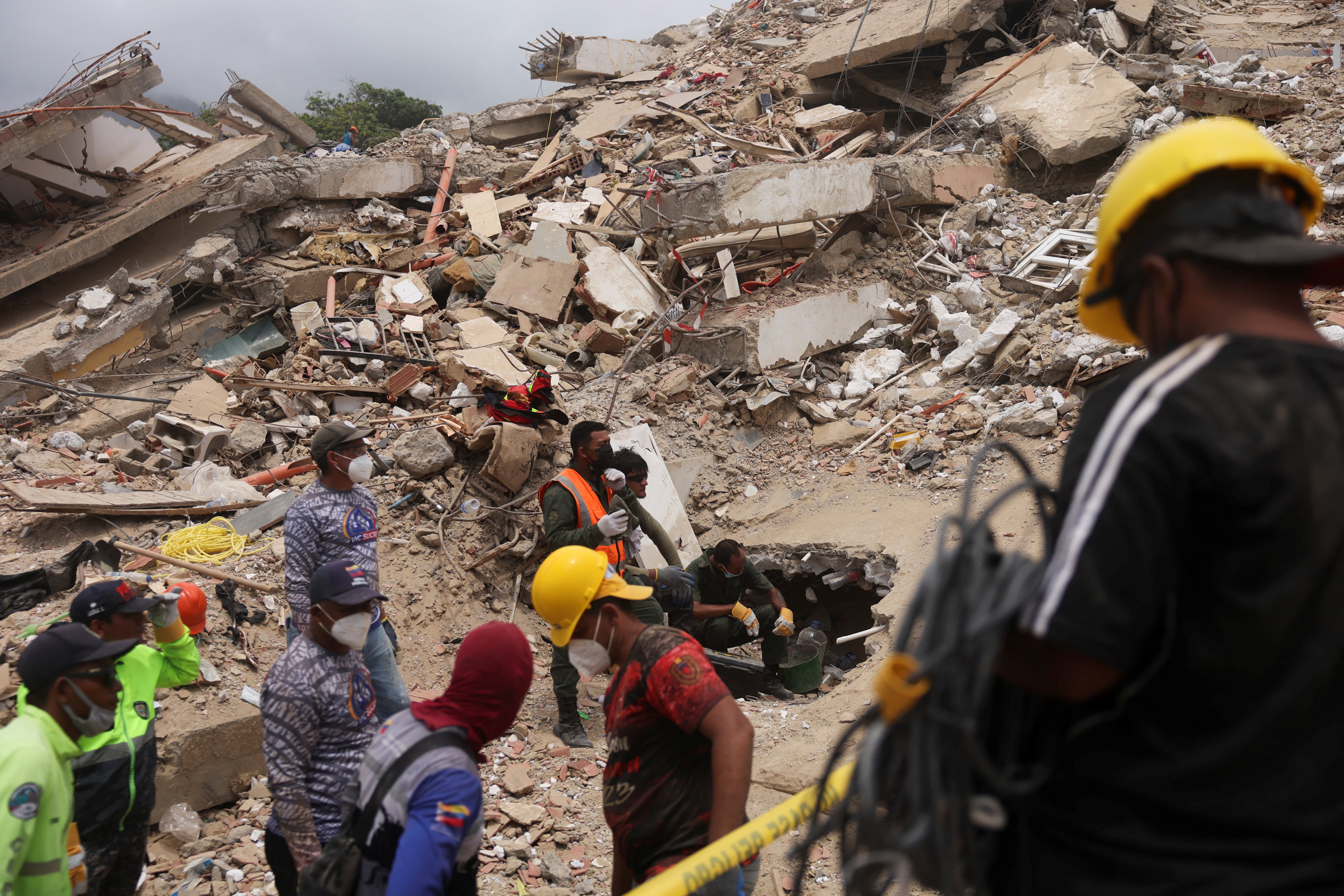 Rescatistas trabajan en el sitio de un edificio colapsado tras los terremotos del 24 de junio en Caraballeda, estado La Guaira (REUTERS)