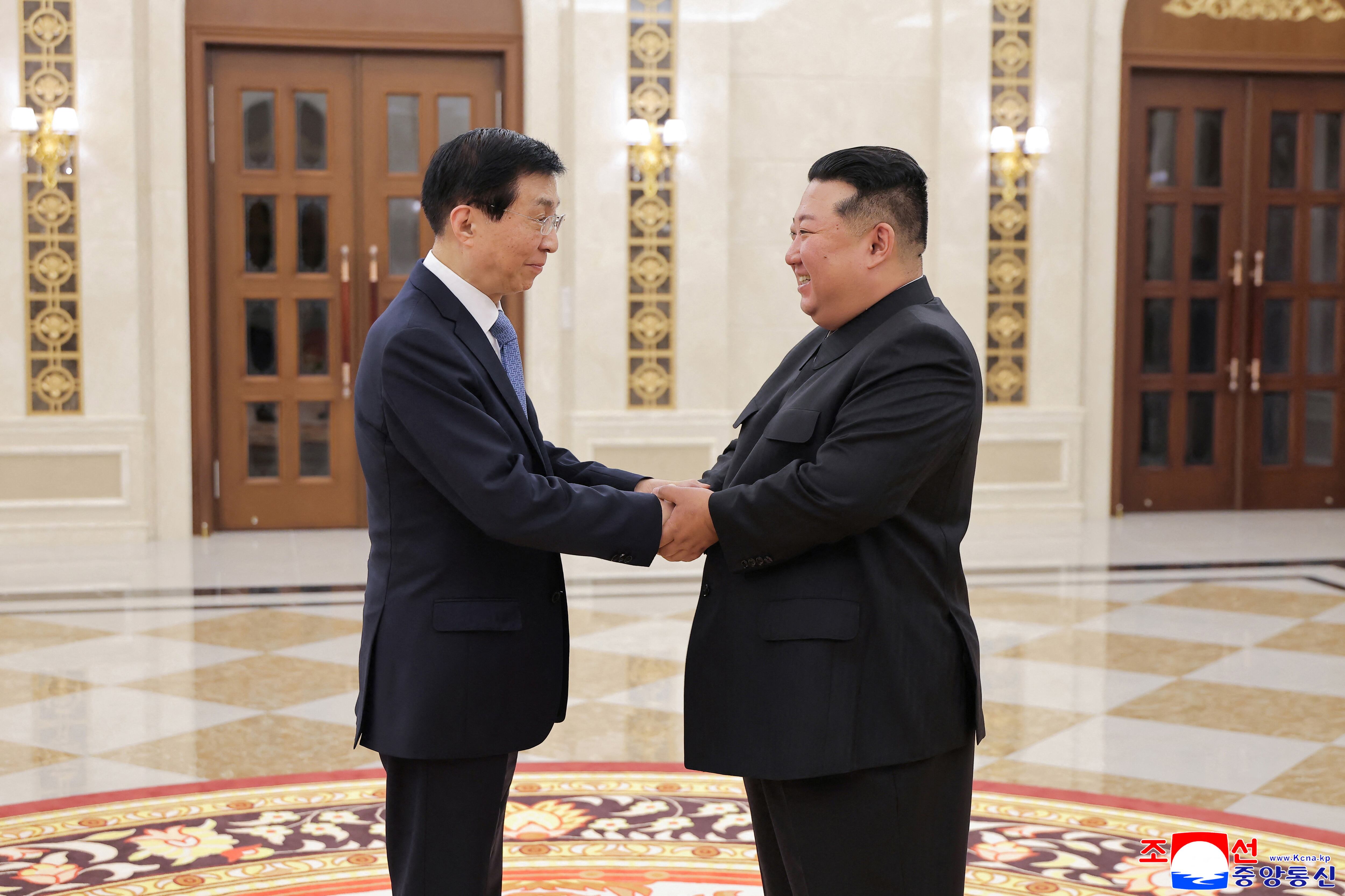 El dictador Kim Jong-un Se da la mano con Wang Huning, presidente de la Conferencia Consultiva Política del Pueblo Chino (KCNA vía REUTERS)