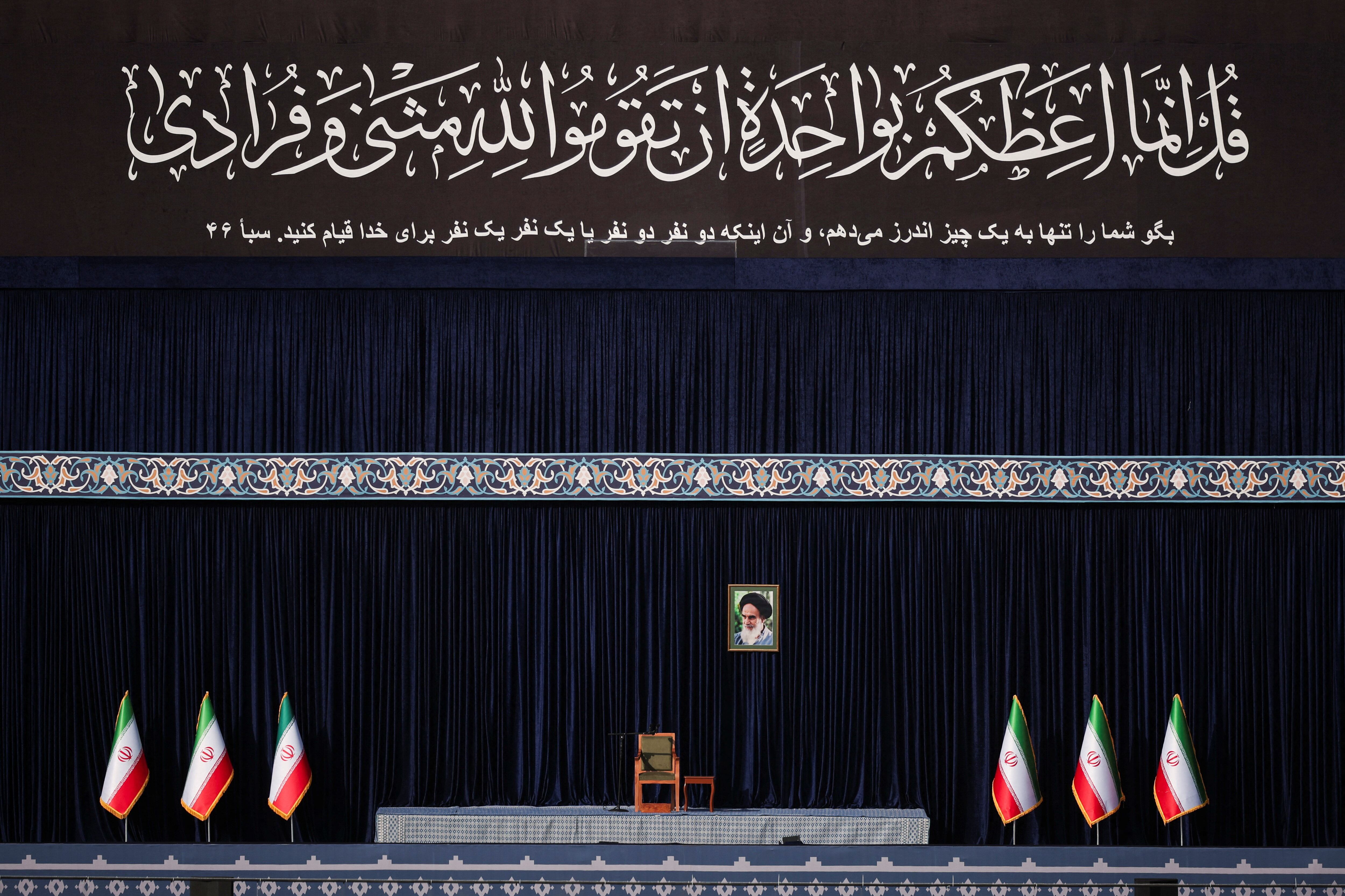 Escenario preparado con un retrato del difunto líder de la Revolución Islámica, el ayatollah Ruhollah Jomeini, y banderas iraníes (REUTERS)