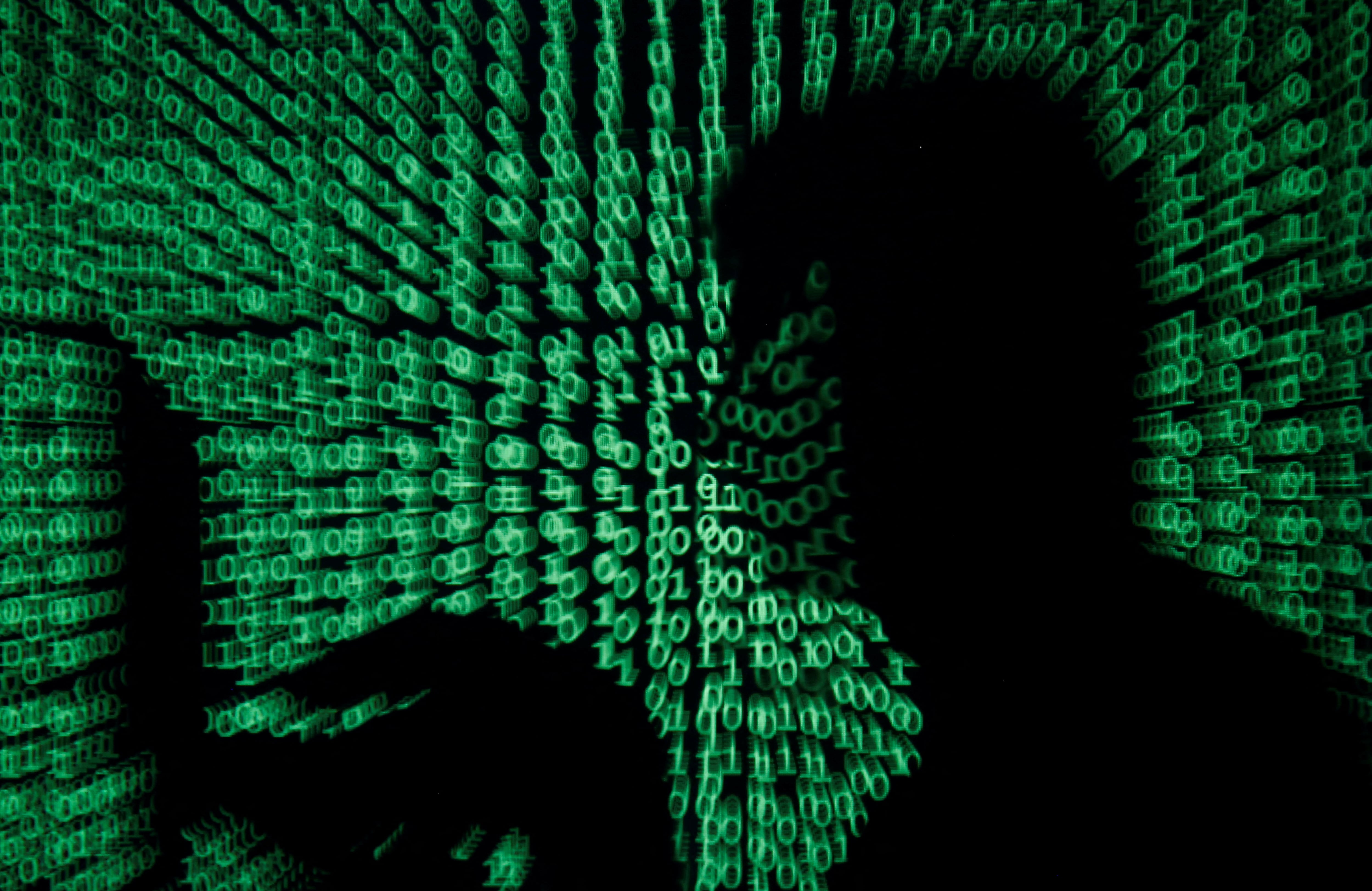 FOTO DE ARCHIVO: Un hombre sostiene una computadora portátil mientras se proyecta código cibernético sobre ella en esta ilustración tomada el 13 de mayo de 2017
REUTERS/Kacper Pempel/Ilustración/Foto de archivo