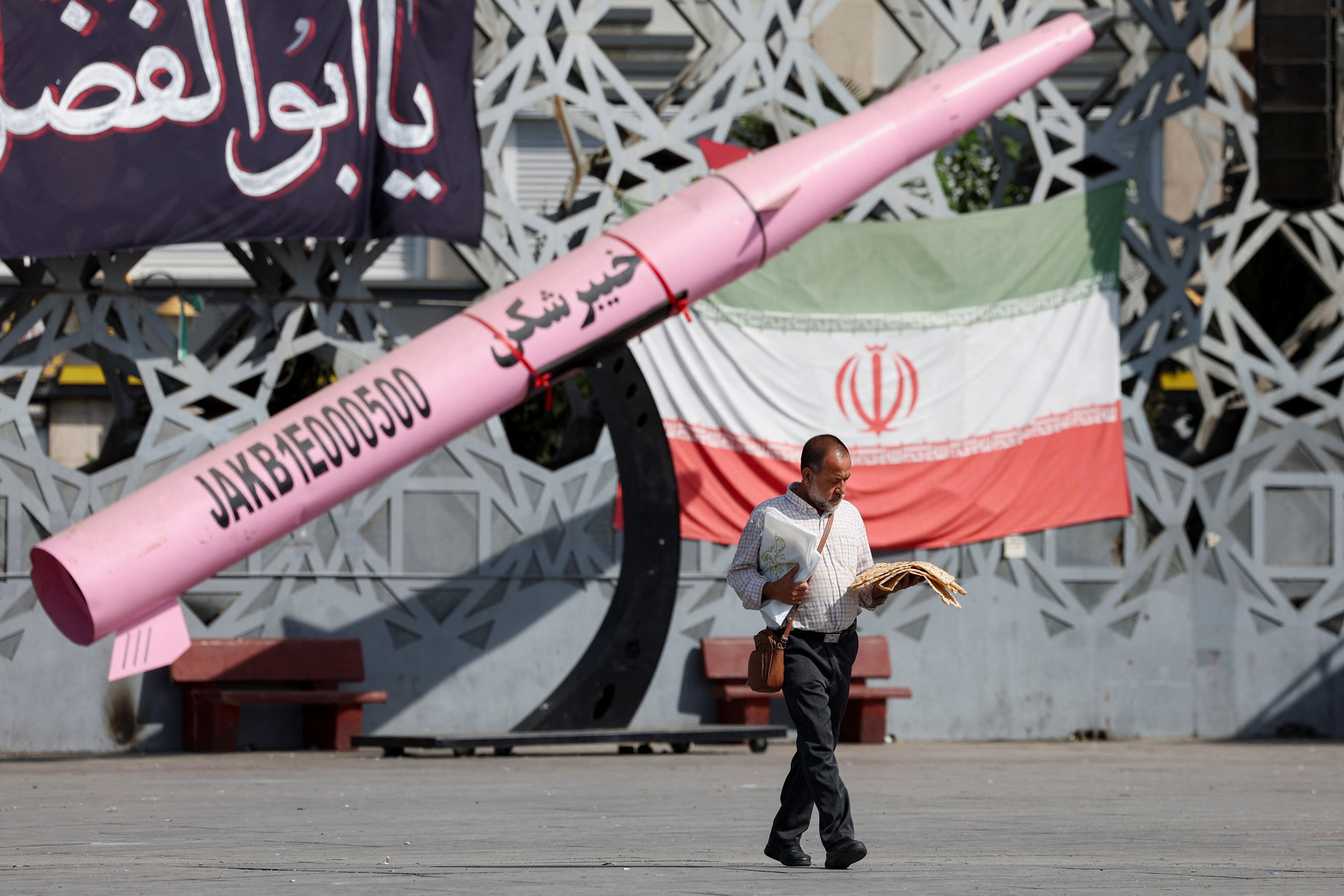 Una réplica de un misil iraní junto a la bandera nacional en la plaza Imam Hussein de Teherán, en medio de la nueva escalada con Estados Unidos (Majid Asgaripour/WANA vía Reuters)