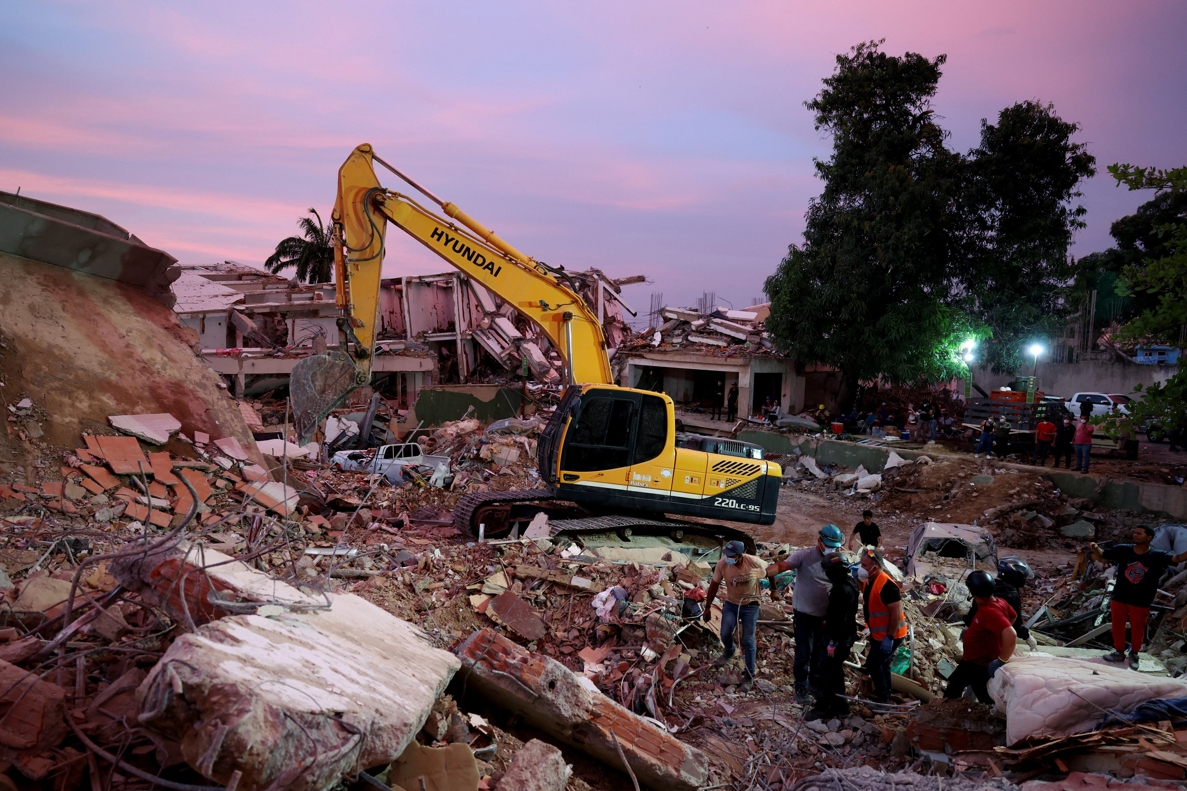 Rescuers work near a heavy machinery operating to clear debris at the site of a collapsed building, in the aftermath of earthquakes, in La Guaira, Venezuela, June 30, 2026. REUTERS/Ricardo Arduengo