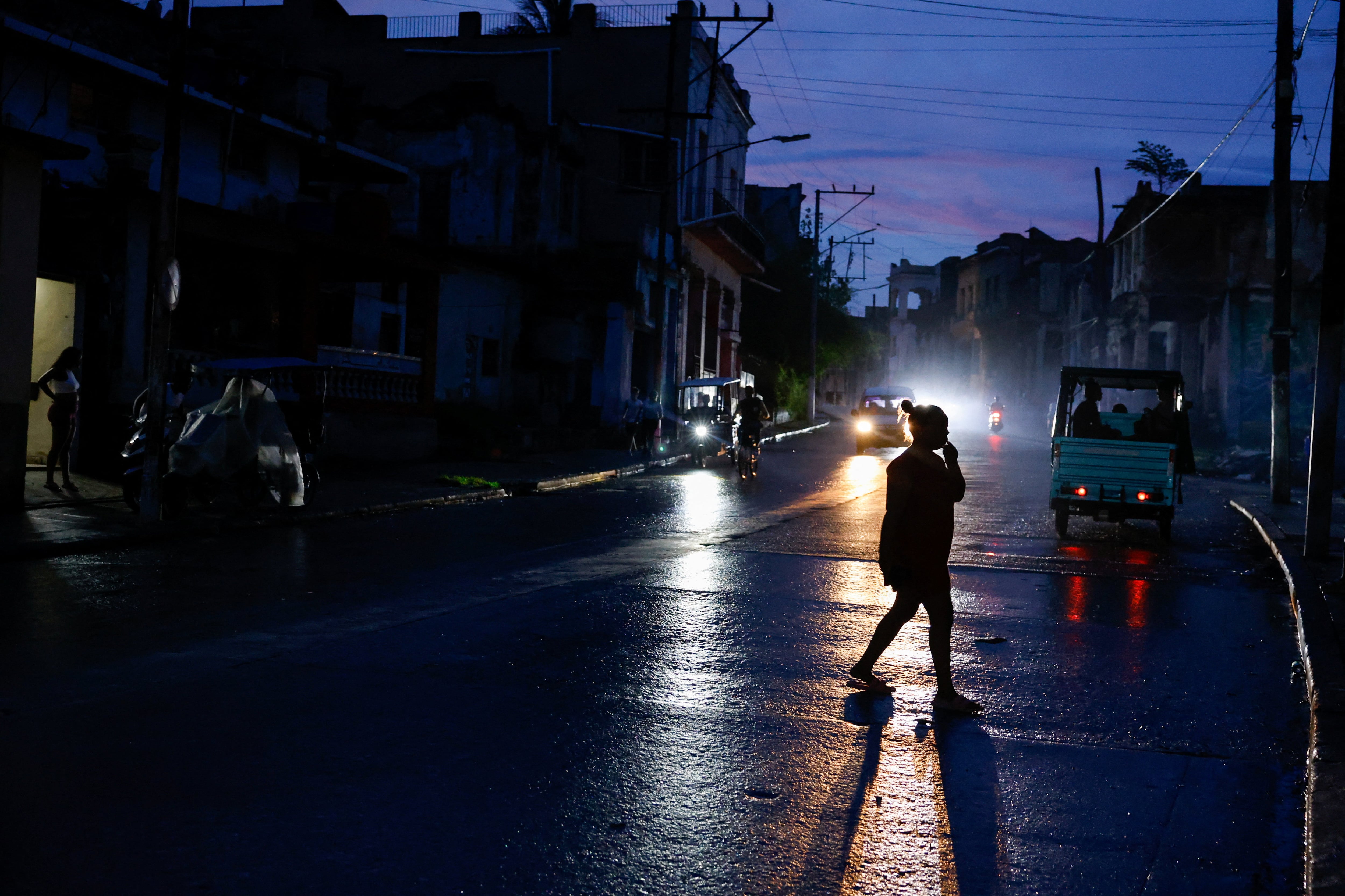 Una mujer cruza una calle durante un apagón en La Habana, donde los cortes llegan a durar 20 horas por la escasez de combustible derivada del bloqueo de EEUU, el 10 de junio de 2026 (REUTERS/Norlys Perez)