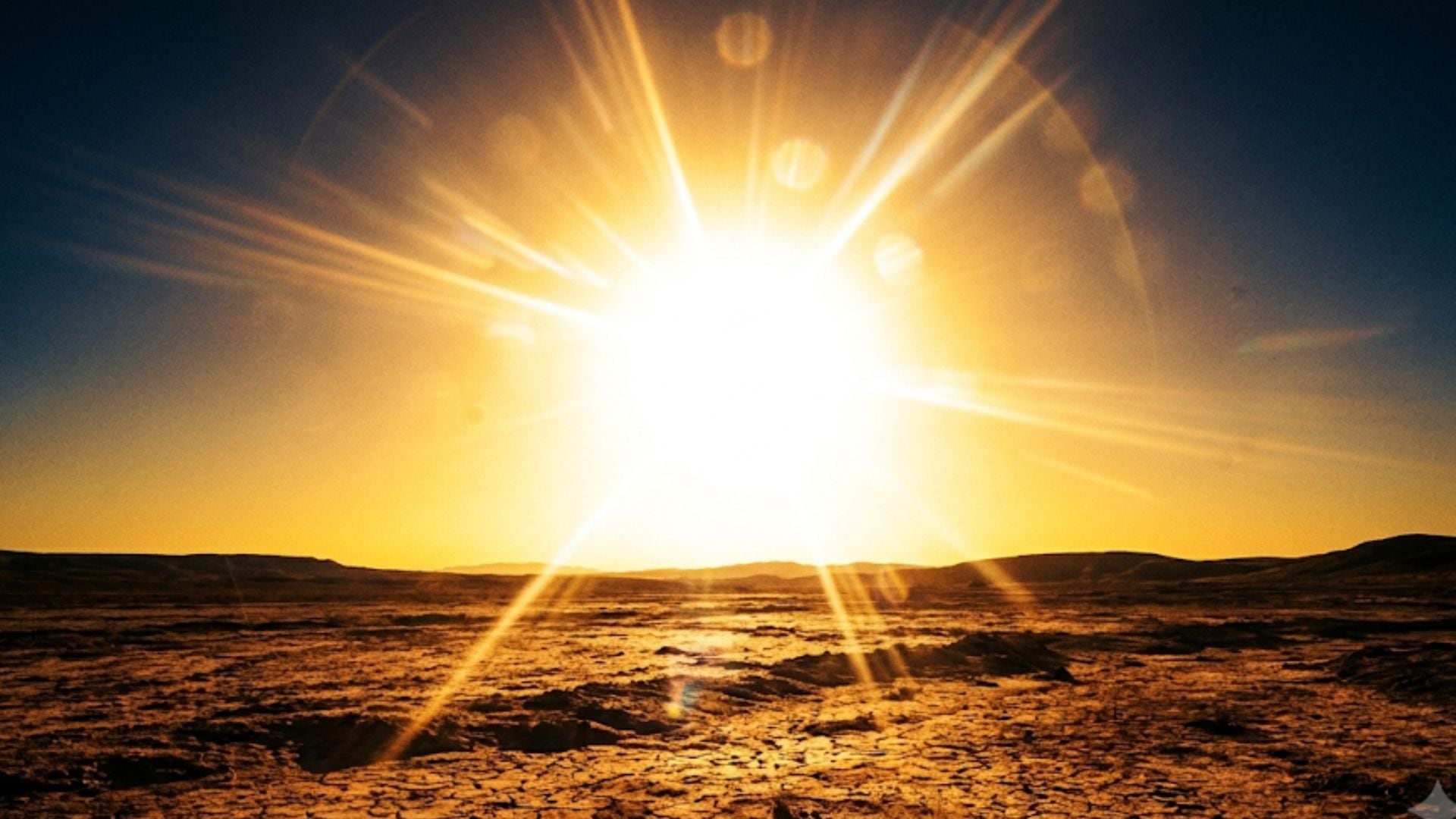 Un sol radiante ilumina un terreno árido y agrietado con montañas distantes bajo un cielo que cambia de azul oscuro a tonos anaranjados. (Imagen Ilustrativa Infobae)
