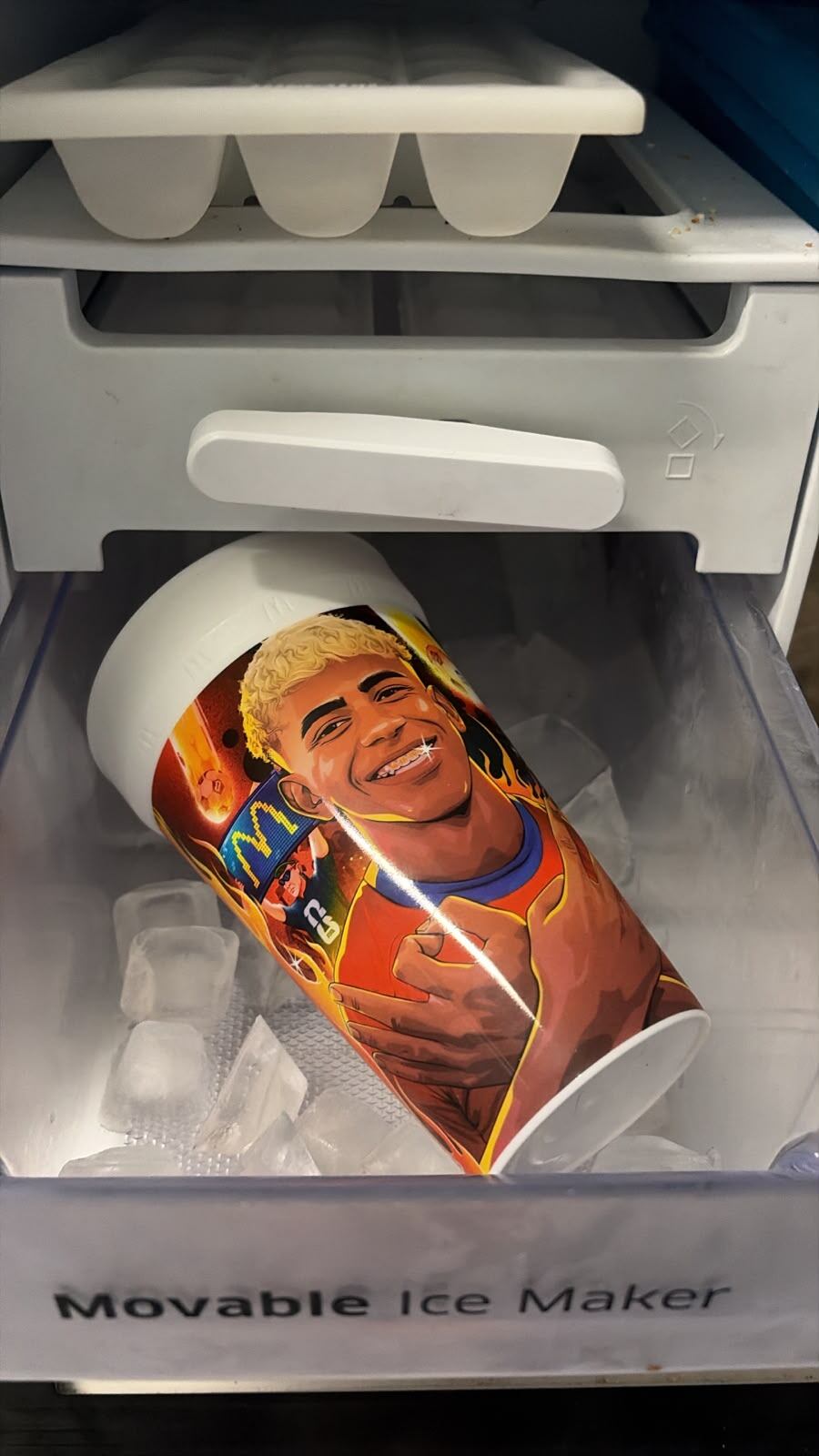 Un vaso con la imagen de Lamine Yamal descansa entre cubos de hielo en el congelador de una heladera argentina, como ritual previo a la final del Mundial.