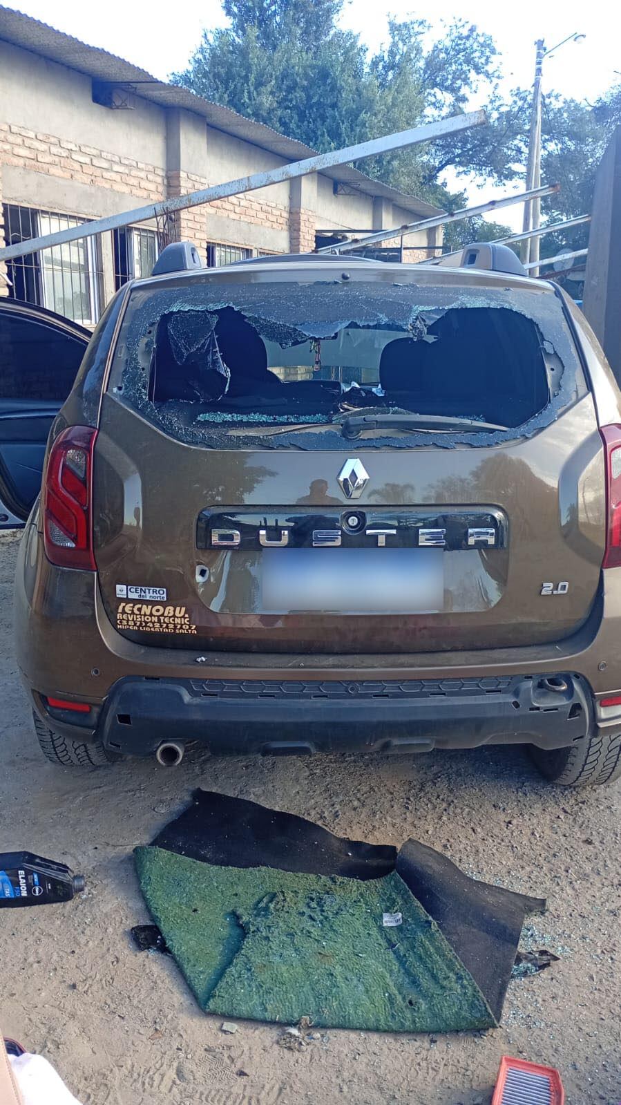 El automóvil Renault Duster con la luneta trasera rota y un orificio de bala