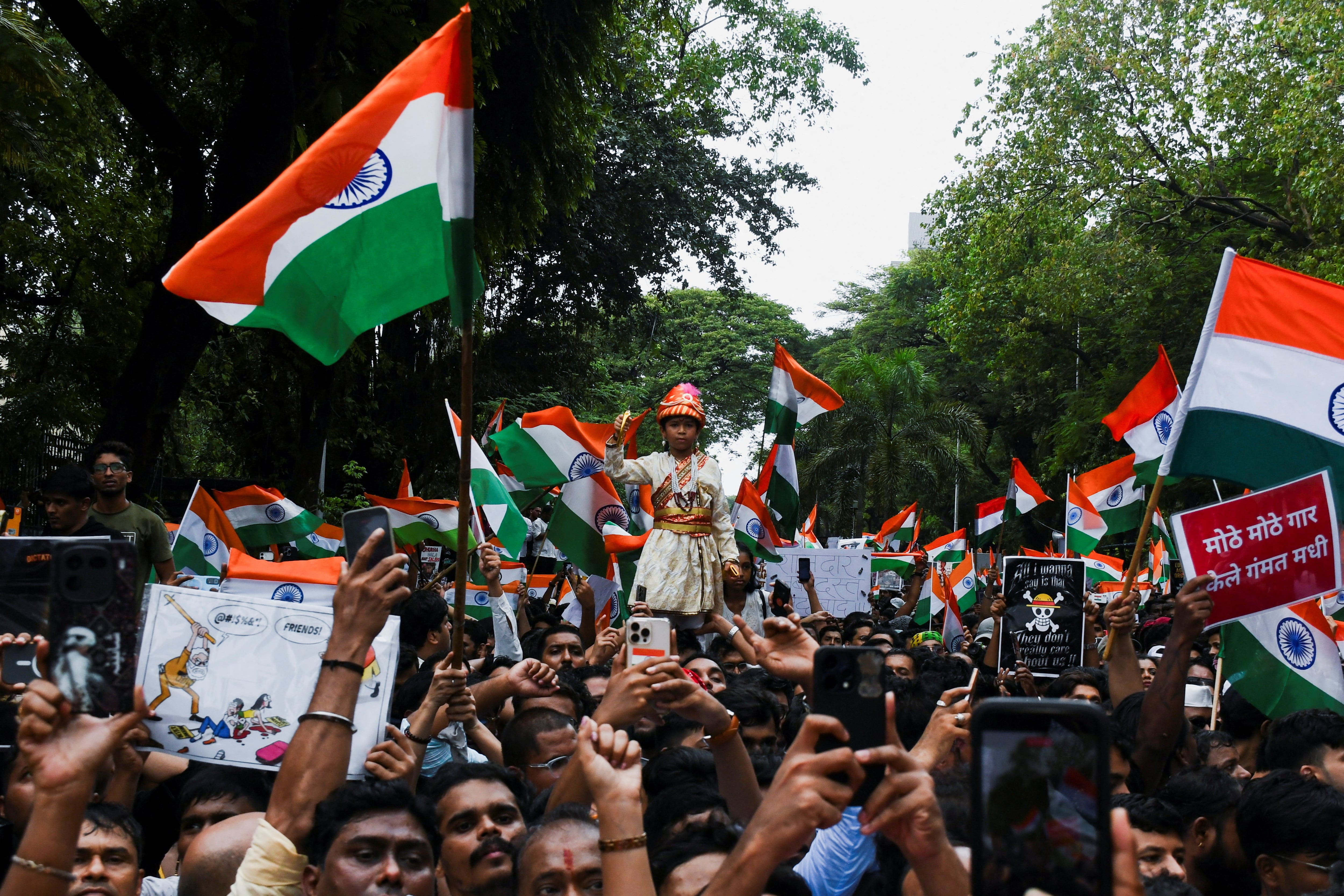 Partidarios del Cockroach Janta Party (CJP) corean consignas, sostienen pancartas y ondean la bandera nacional mientras celebran la dimisión del ministro de Educación, Dharmendra Pradhan, a raíz de las filtraciones del examen de acceso nacional NEET y tras una protesta, en Bombay (India), el 26 de julio de 2026 (REUTERS)