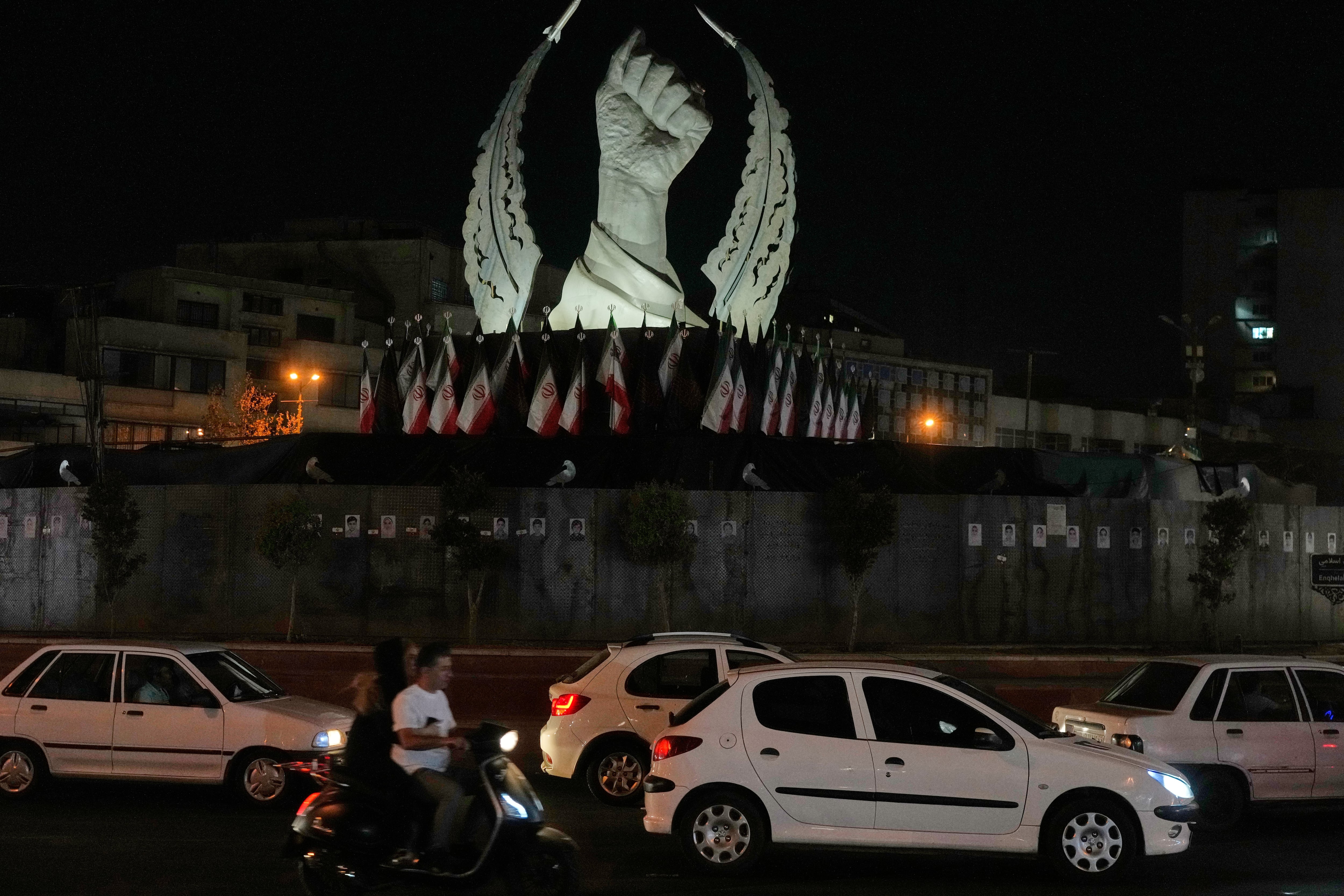 Varios vehículos pasan ante un monumento que muestra el puño cerrado del ex líder supremo iraní Ali Khamenei, asesinado en ataques de Estados Unidos e Israel el 28 de febrero, en la plaza de la Revolución Islámica en Teherán, Irán, el domingo 19 de julio de 2026 (AP Foto/Vahid Salemi)