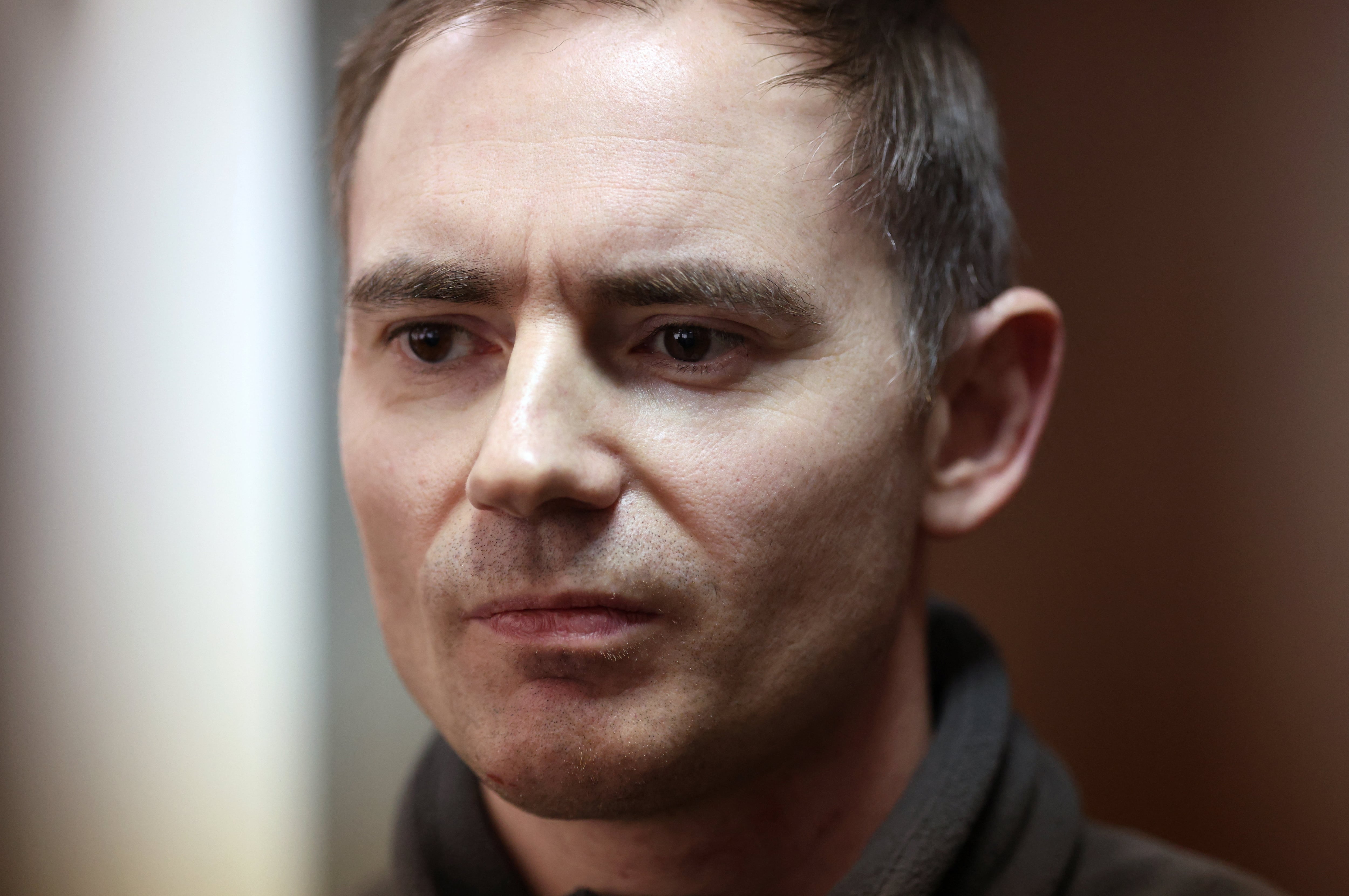 Maxim Kruglov, líder adjunto del partido liberal ruso Yabloko —acusado de difundir deliberadamente mentiras sobre el ejército ruso en medio del conflicto militar contra Ucrania—, permanece en el recinto para acusados antes de una audiencia judicial en Moscú, Rusia, el 22 de abril de 2026 (REUTERS/Ramil Sitdikov)