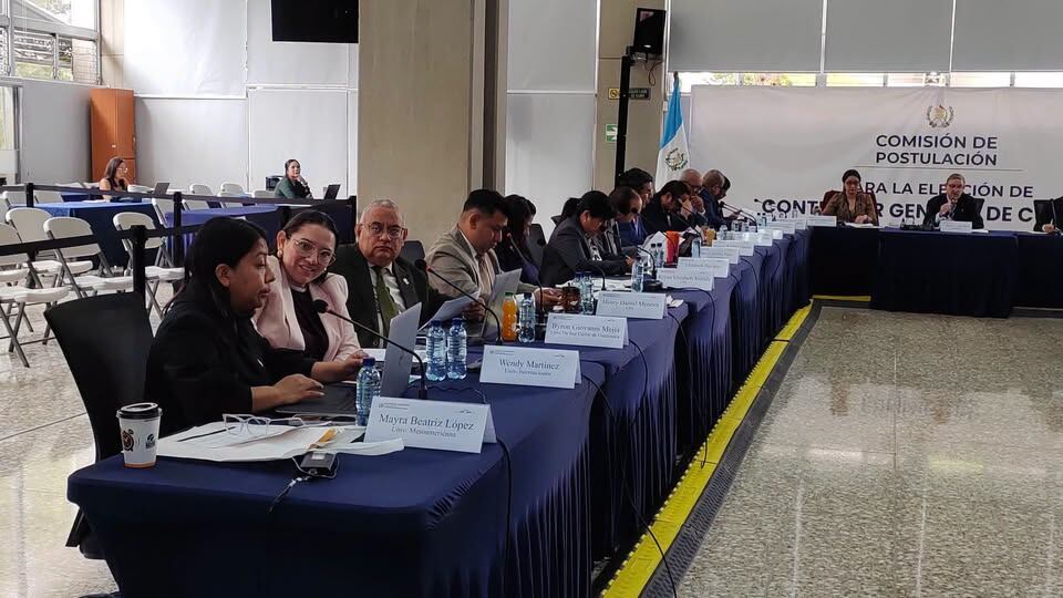 La Comisión de Postulación se reúne en una sala de conferencias para el proceso de elección del Contralor General de Cuentas, con varios miembros sentados en una mesa. (Guatemala Visible)