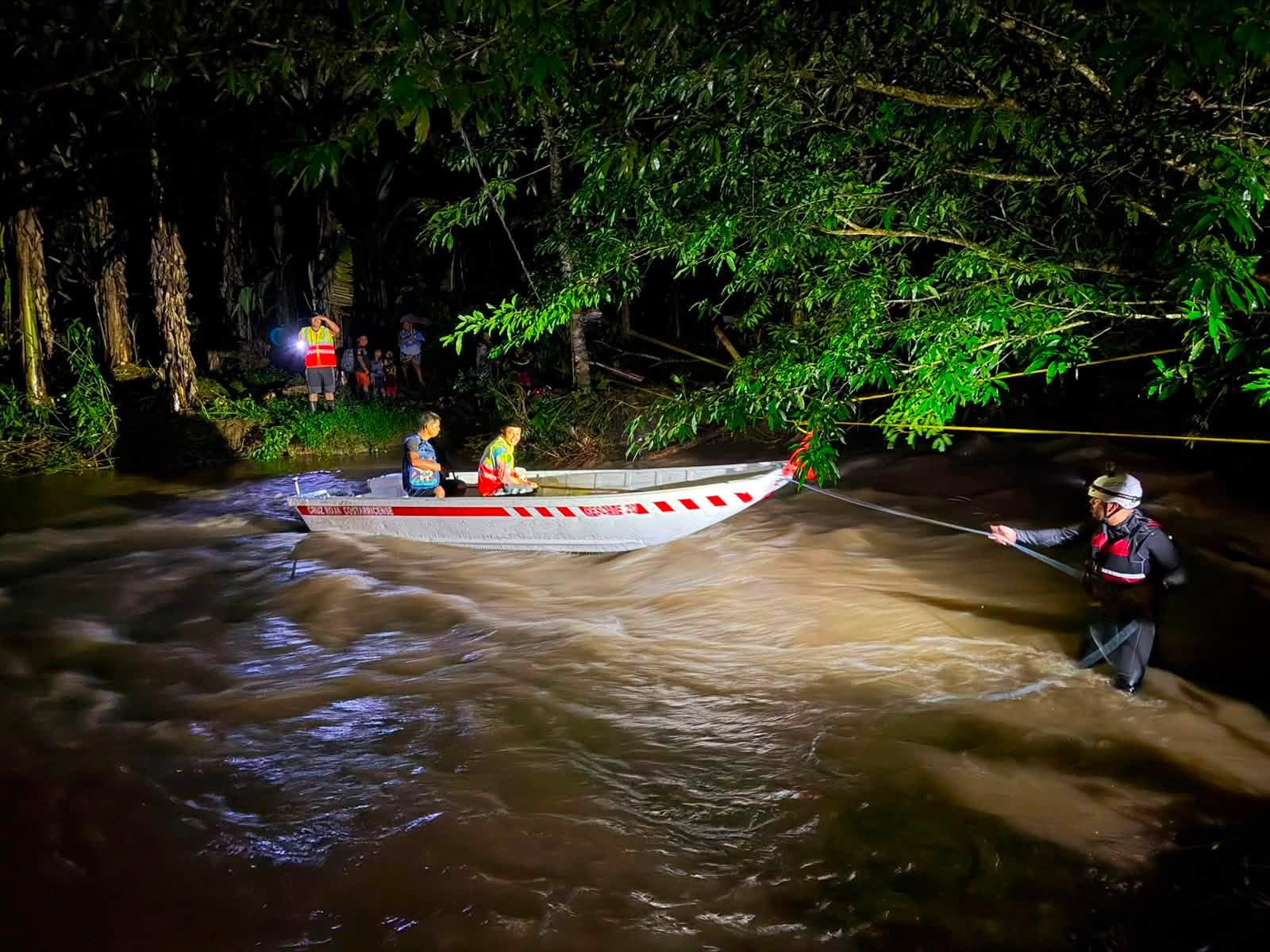 Rescatistas atraviesan un río crecido durante la noche para evacuar a personas afectadas por las inundaciones en la Zona Norte de Costa Rica (Cortesía: Cruz Roja).