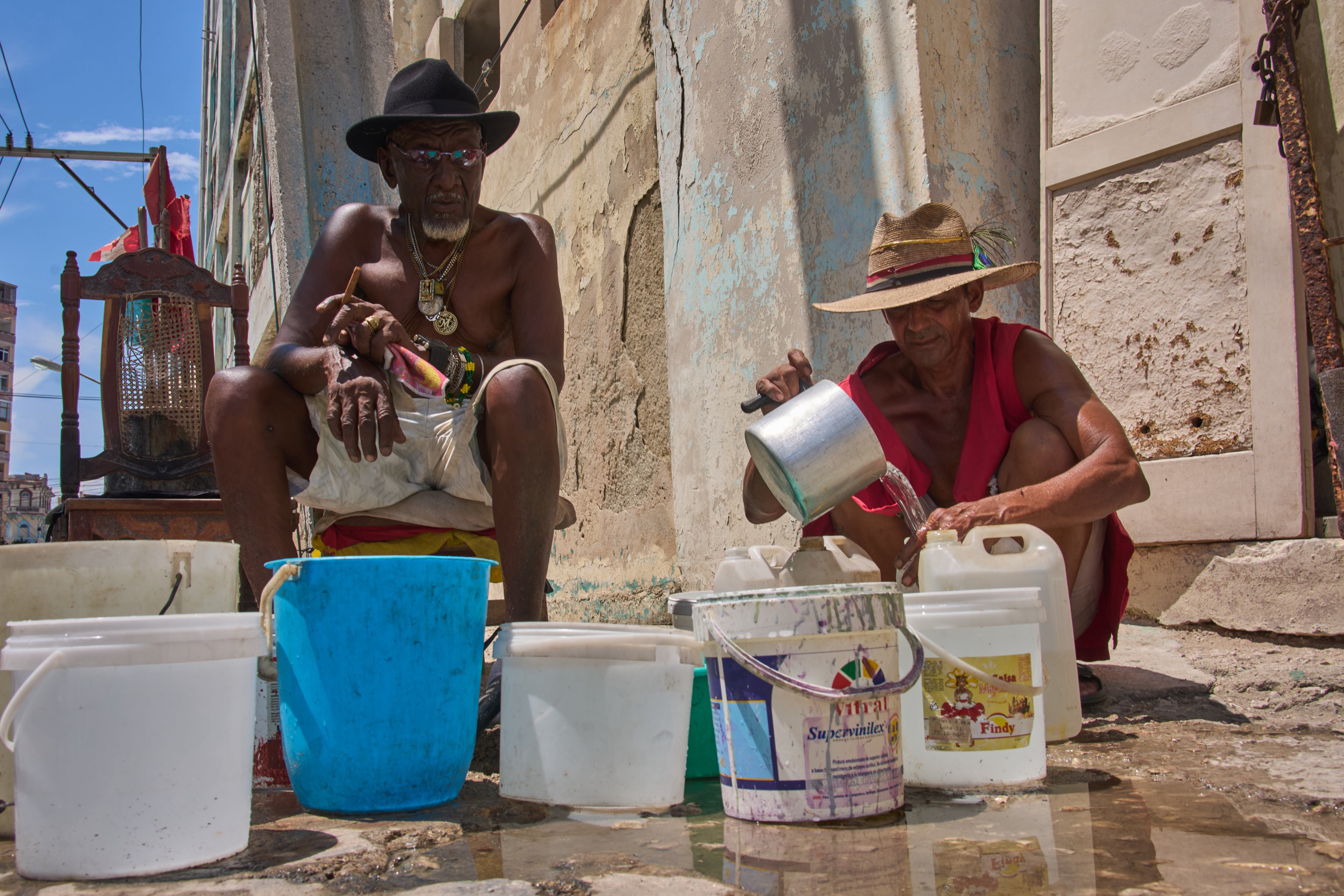 Oscar Joaquín López (izquierda) y su compañero de vivienda Wilfredo Cisneros Duarte recogen agua de una tubería callejera en La Habana, Cuba, el lunes 7 de septiembre de 2026. (Foto AP/Ramon Espinosa)