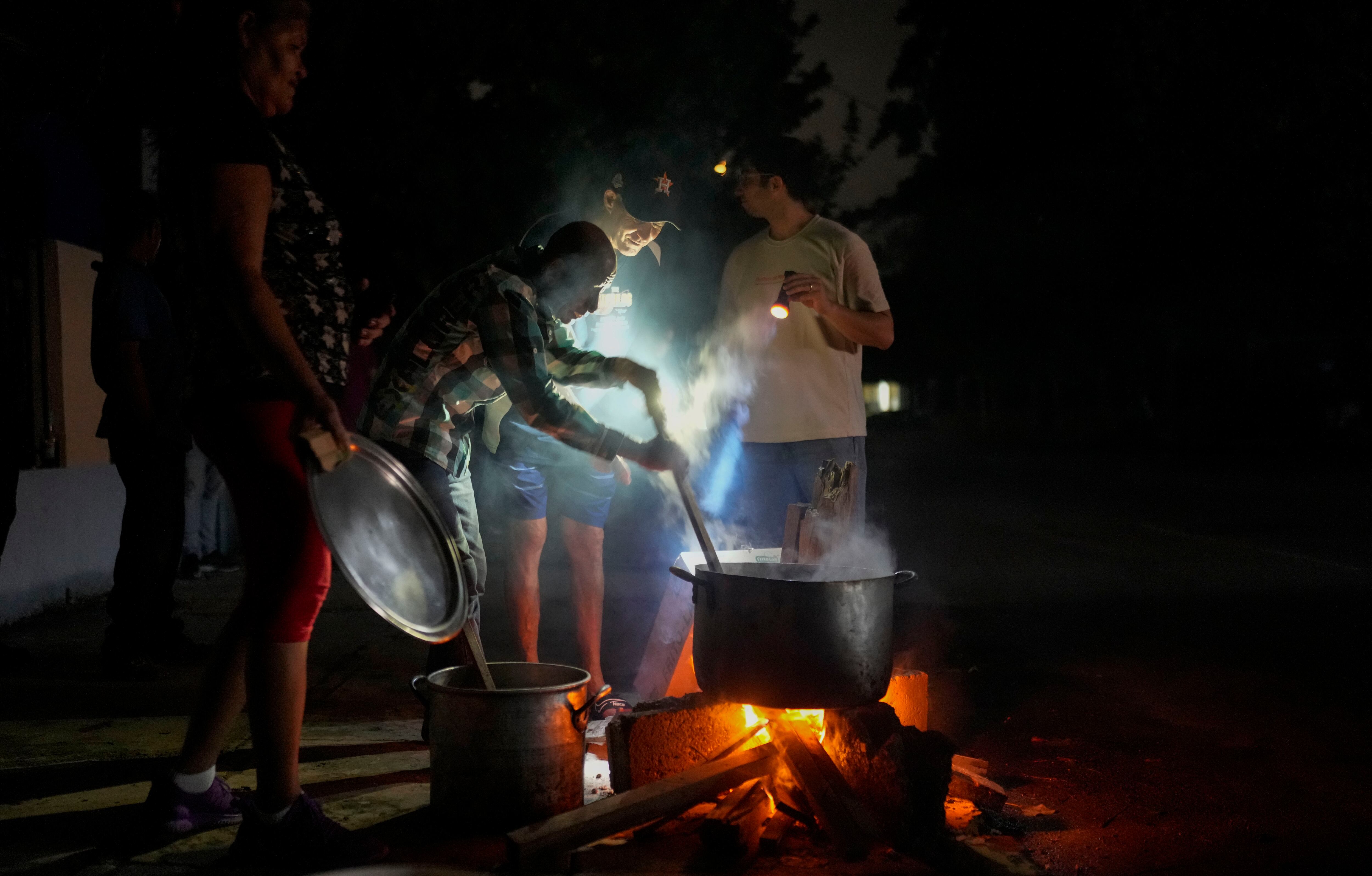 Residentes preparan sopa en un fuego de leña al aire libre durante un apagón tras un problema en una importante central eléctrica, en La Habana, Cuba, el 19 de octubre de 2024. (AP Foto/Ramón Espinosa)