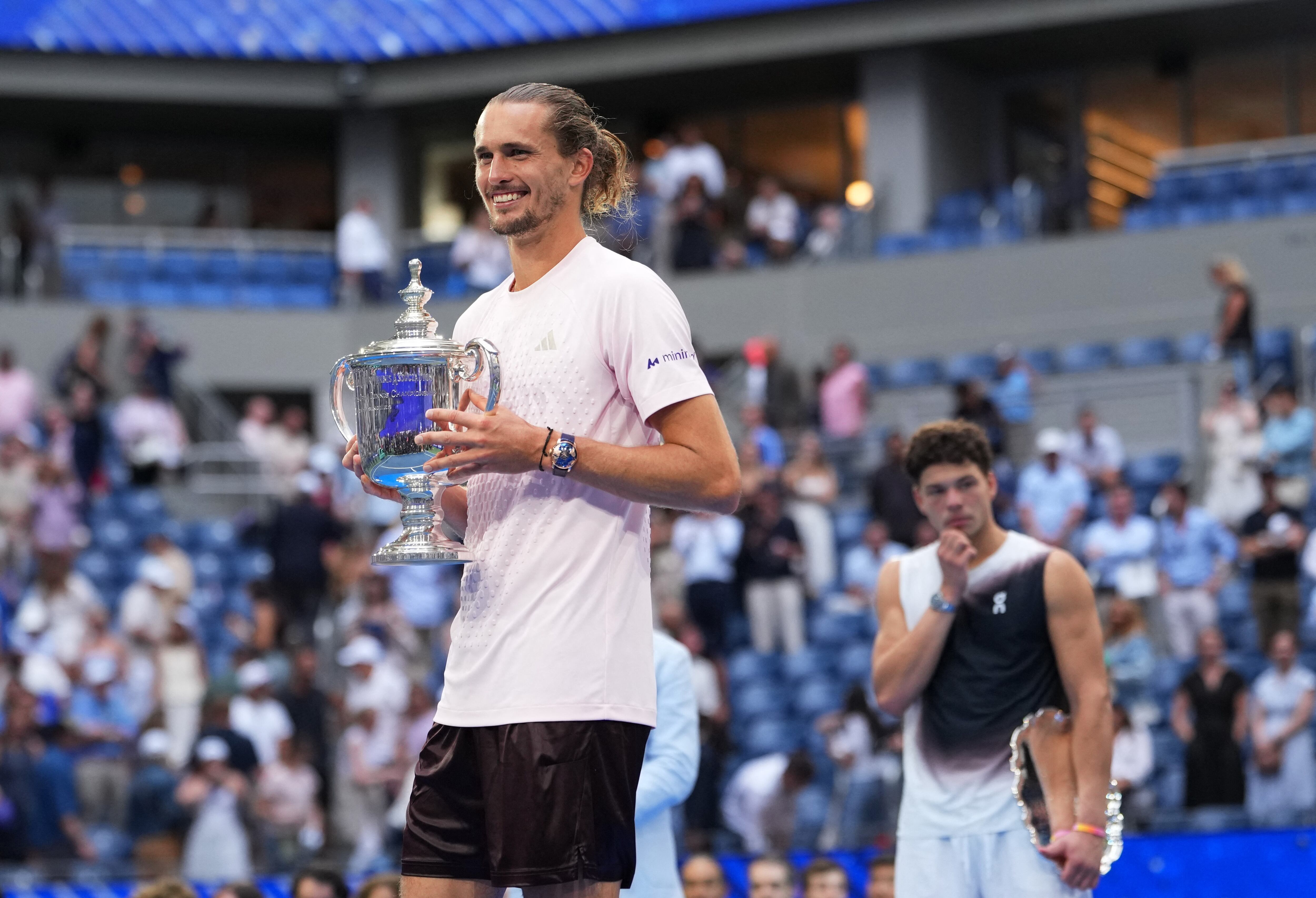 Alexander Zverev sostiene el trofeo del US Open. Detrás suyo, Ben Shelton (Crédito: Reuters/Robert Deutsch)