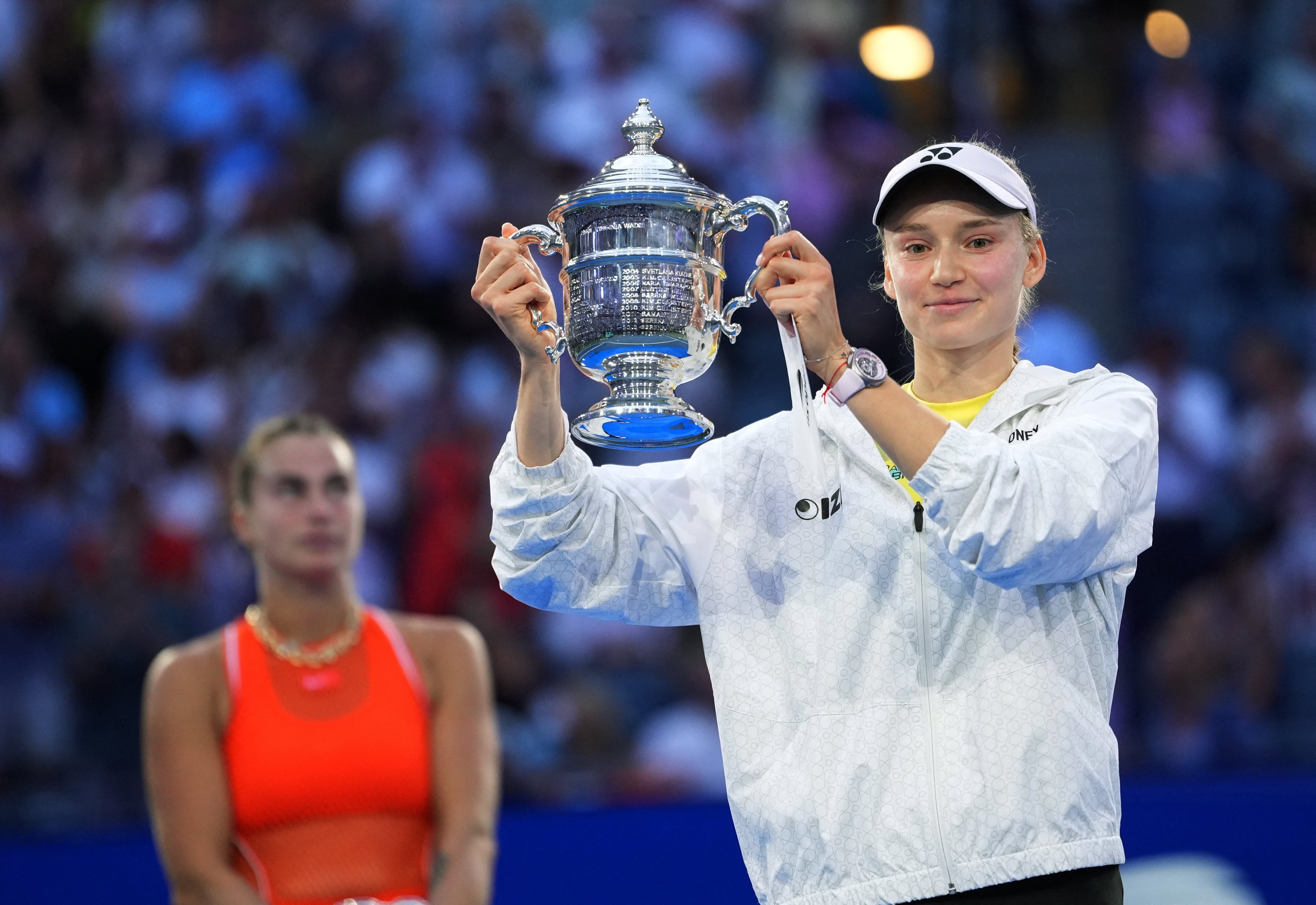 Elena Rybakina con el trofeo del US Open 2026. Detrás suyo, Aryna Sabalenka (Crédito: Reuters/Robert Deutsch)
