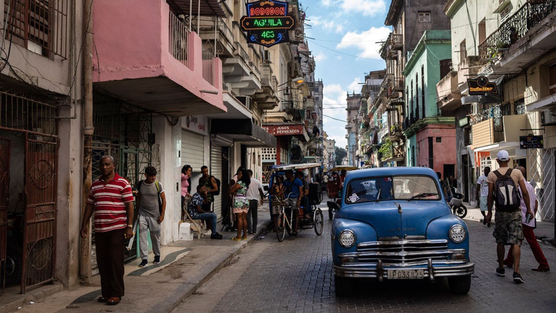 Varias personas caminan bajo el cartel que anuncia la existencia de una tienda de comestibles privada en La Habana, Cuba, el 11 de noviembre de 2023. En los últimos meses, en toda la isla han surgido decenas de negocios bautizados como “mipymes”, que ofrecen verdaderos tesoros, aunque a precios elevados para la mayoría de la población. (AP Foto/Ramón Espinosa)