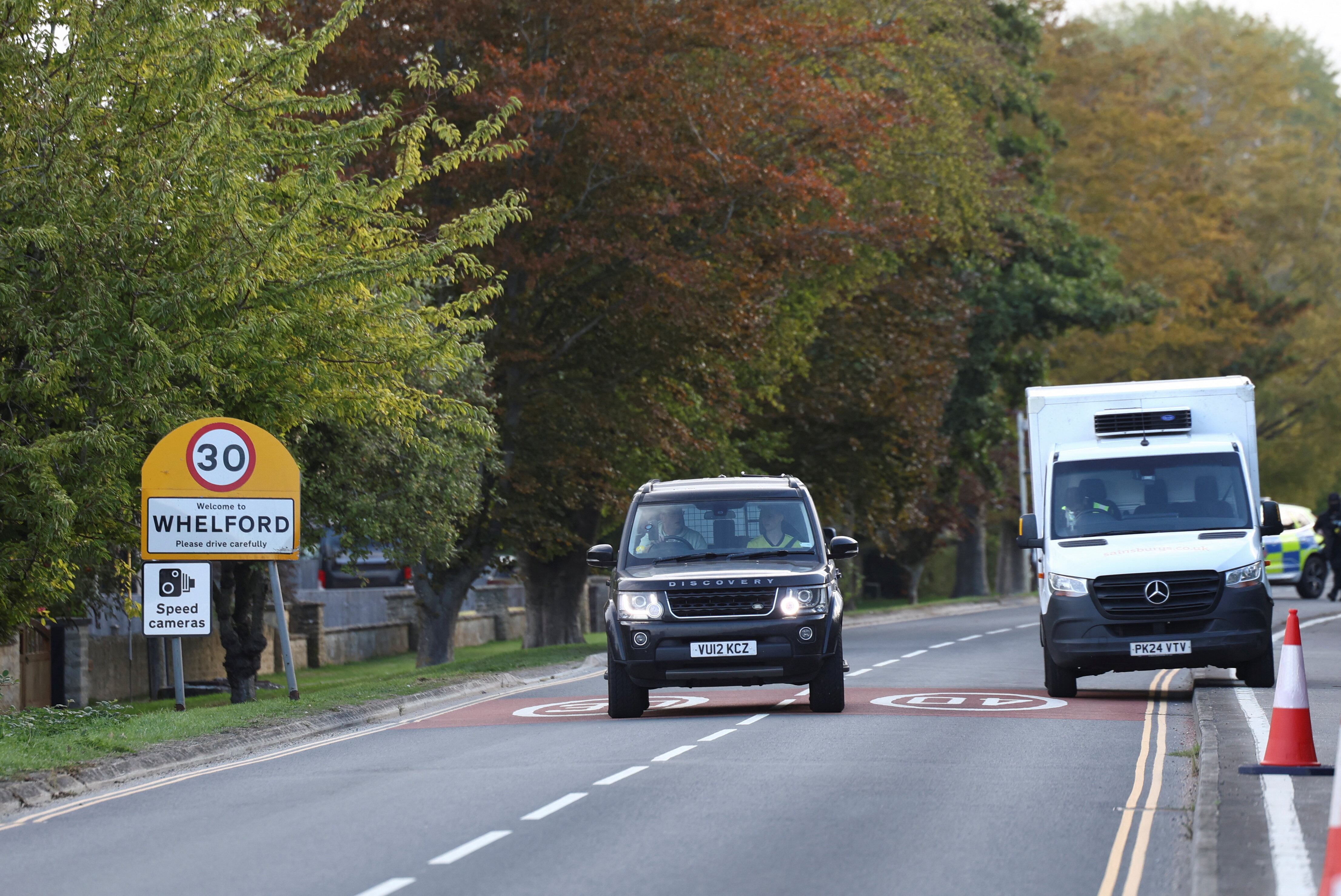 Un vehículo pasa junto a un cartel de Whelford mientras la policía bloquea las rutas cercanas a la base aérea RAF Fairford, en Gloucestershire, Reino Unido, el 27 de septiembre de 2026. Las autoridades evacuaron a los residentes de 85 viviendas de la aldea (REUTERS/Toby Shepheard)