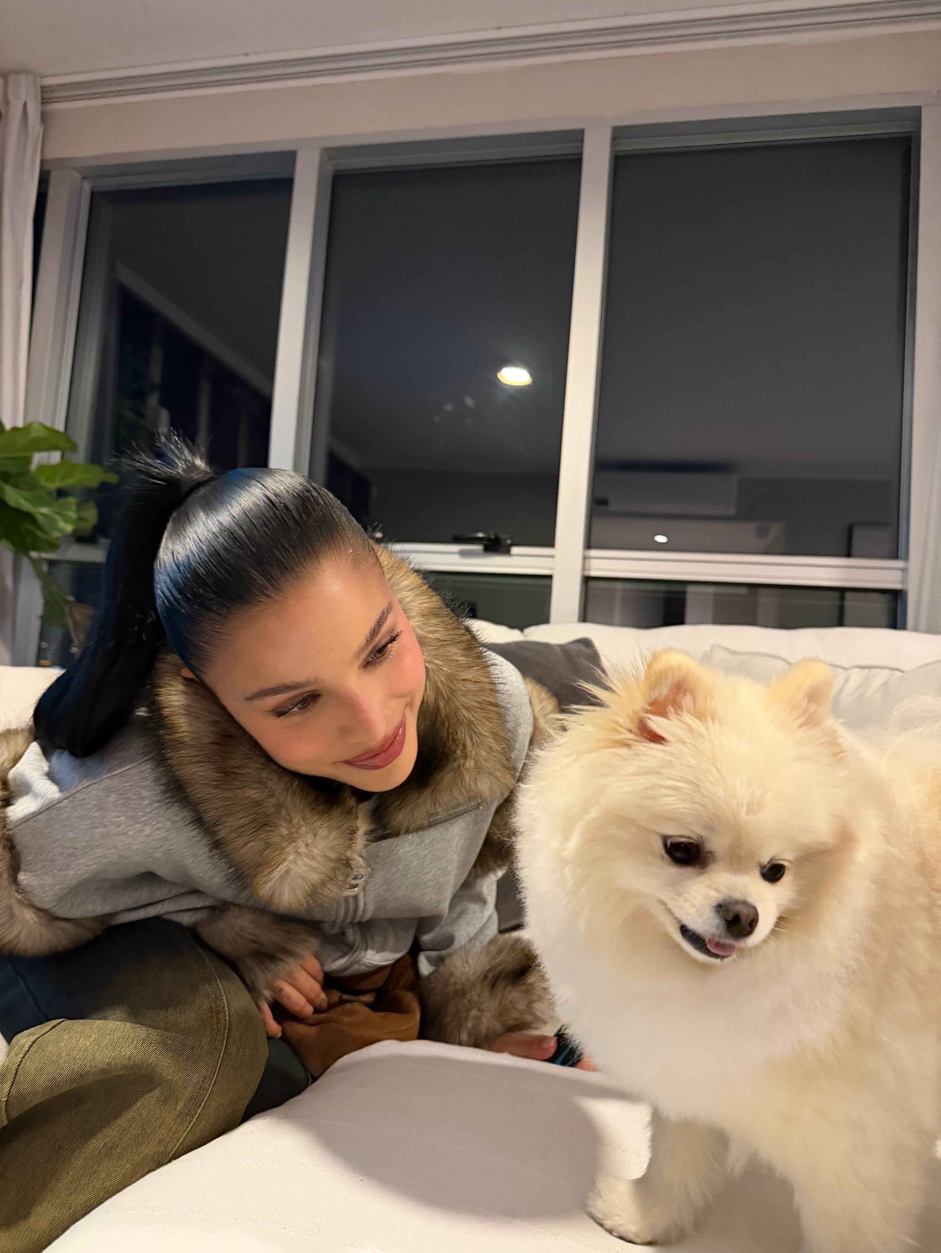  Mernes junto a su mascota, Roma, quien posa en el sillón de su hogar