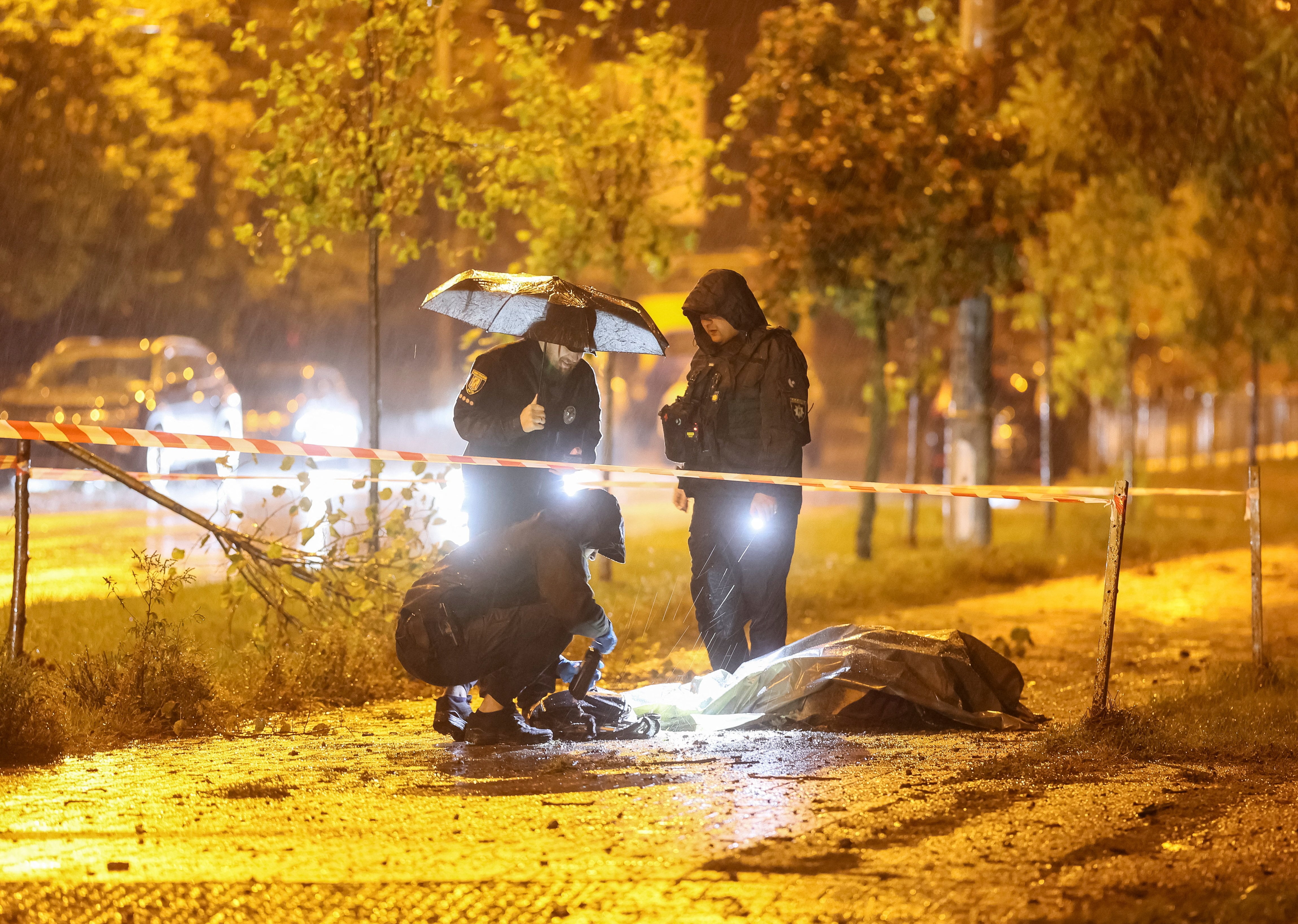 Agentes de policía trabajan cerca del cuerpo de un residente fallecido, cubierto con una bolsa de plástico, en el lugar de un ataque con misiles rusos cerca de una maternidad, en el marco de la ofensiva rusa contra Ucrania, en Kiev (Ucrania), el 24 de septiembre de 2026 (REUTERS/Gleb Garanich)