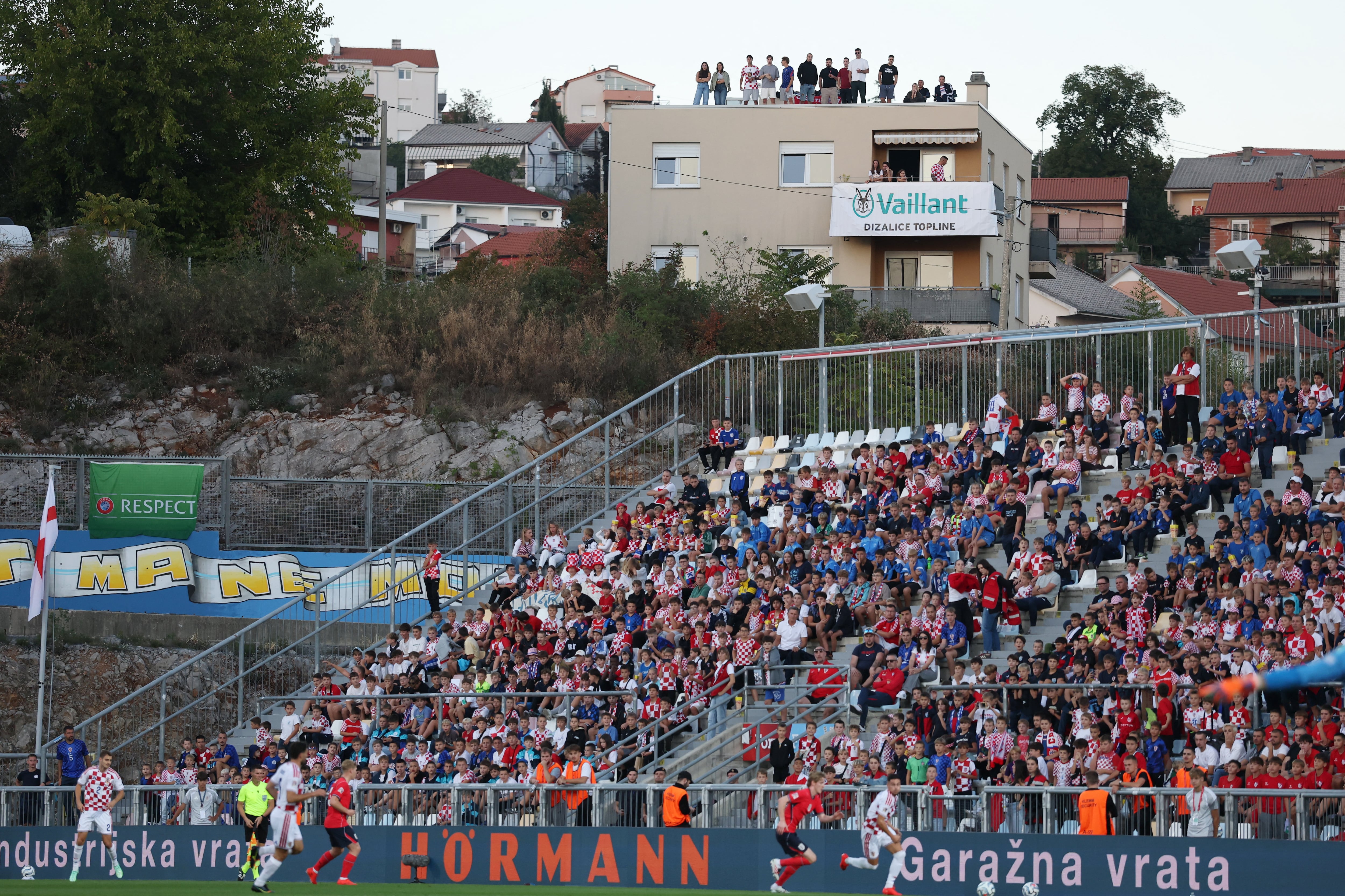 Sólo se permitió el ingreso a las tribunas a niños: algunos aficionados se las ingeniaron para ver el partido desde afuera de la cancha (Foto: Reuters/Paul Childs)
