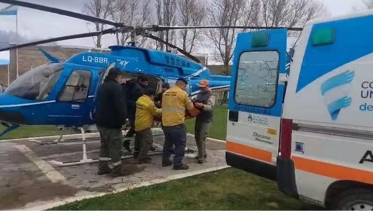 El personal de emergencia trasladó al paciente en camilla entre una ambulancia del Hospital Loncopué y un helicóptero sanitario