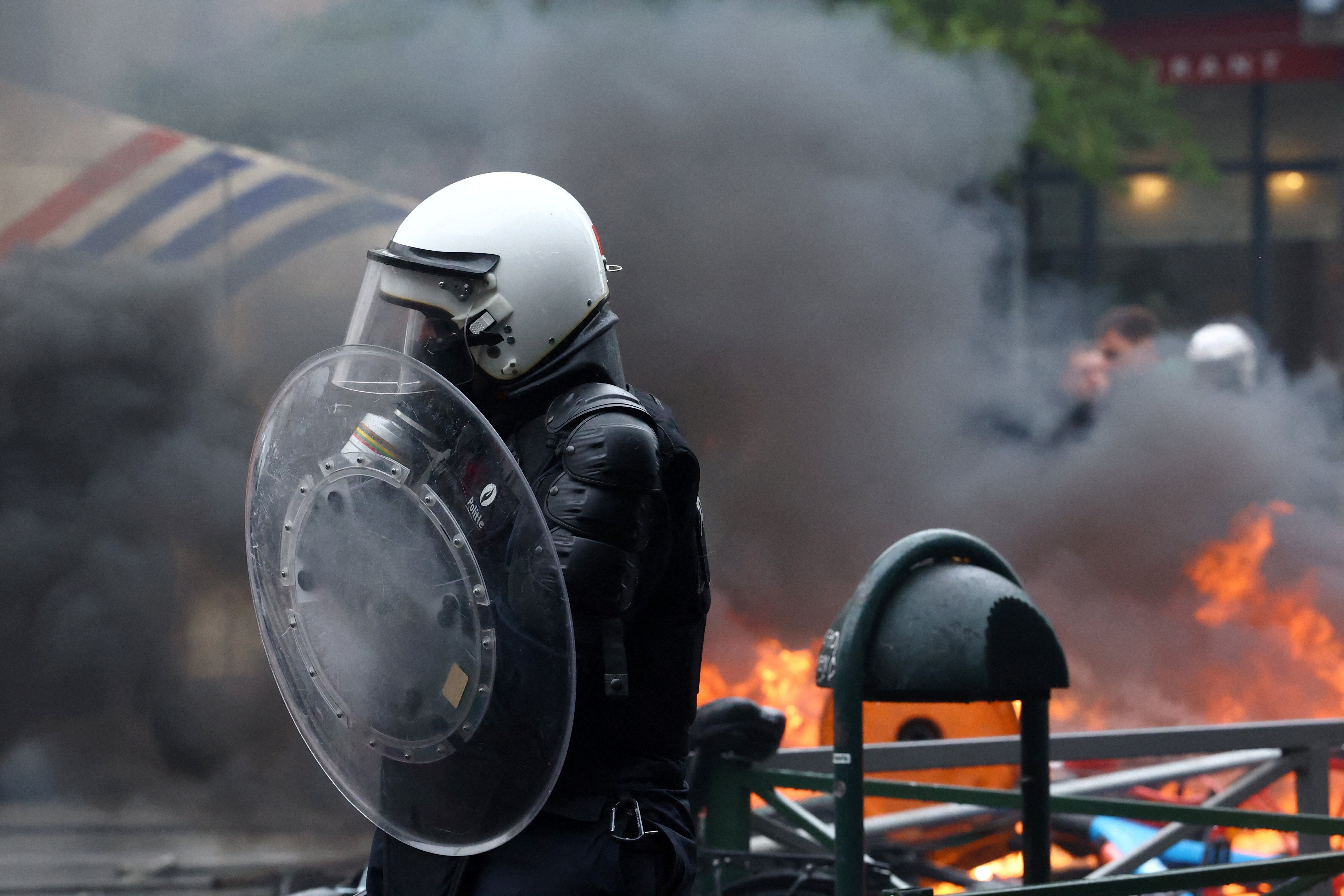 Un miembro de la policía se encuentra cerca de una barricada en llamas mientras estudiantes manifestantes se suman a una huelga nacional contra las medidas de austeridad y los recortes presupuestarios del Gobierno belga, en Bruselas, Bélgica, el 9 de octubre de 2026. REUTERS/Yves Herman