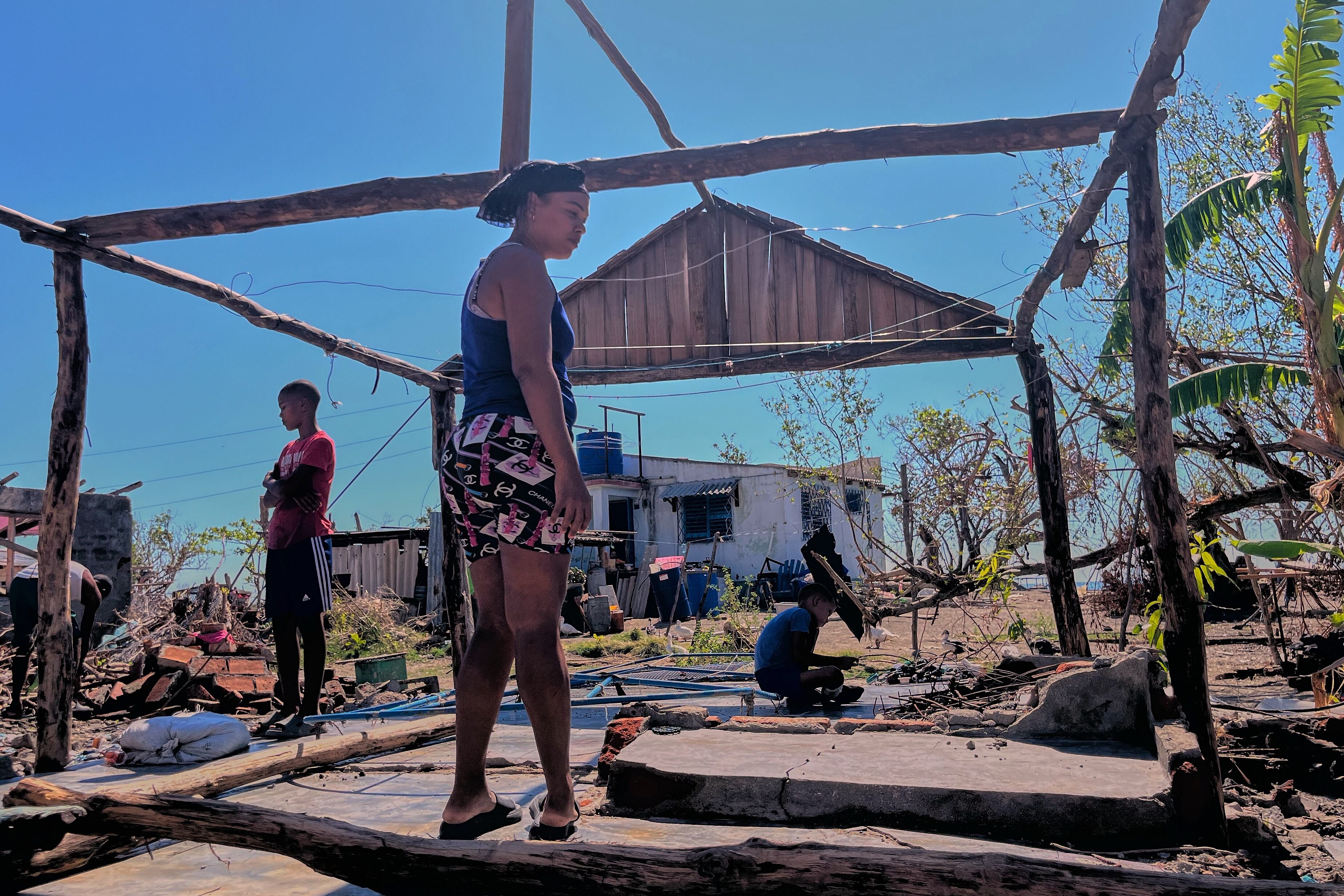 Elizandra Sorrilla posa para una foto entre las ruinas de su vivienda, destruida por el huracán Melissa, en El Aserradero, Cuba, el domingo 16 de noviembre de 2025. (AP Foto/Milexsy Duran)