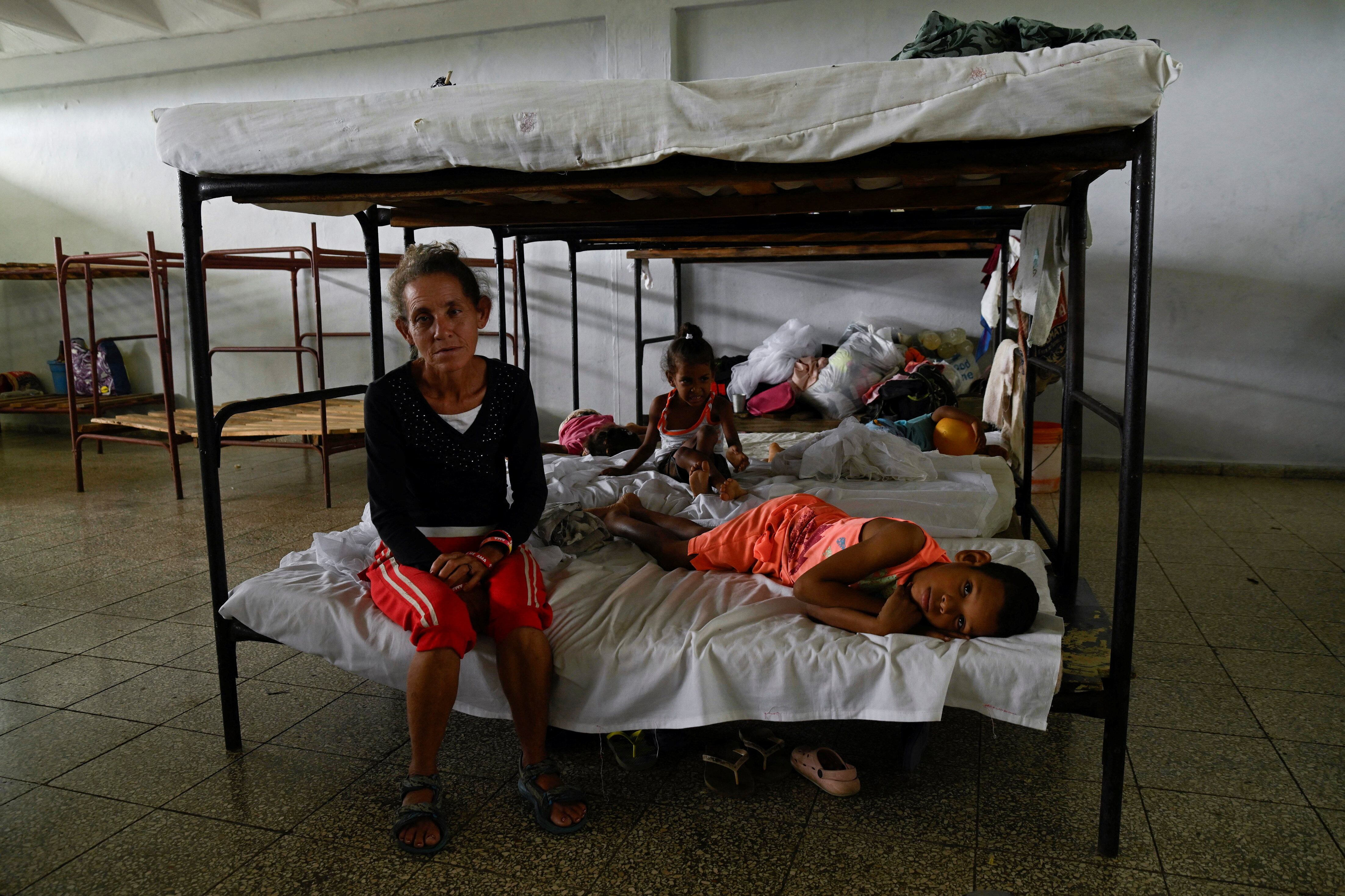 Ramona Sablon, 51, rests with her grandson in a shelter where they were moved as a precautionary measure as people prepare for the arrival of Hurricane Melissa, in Santiago de Cuba, Cuba, October 27, 2025. REUTERS/Norlys Perez