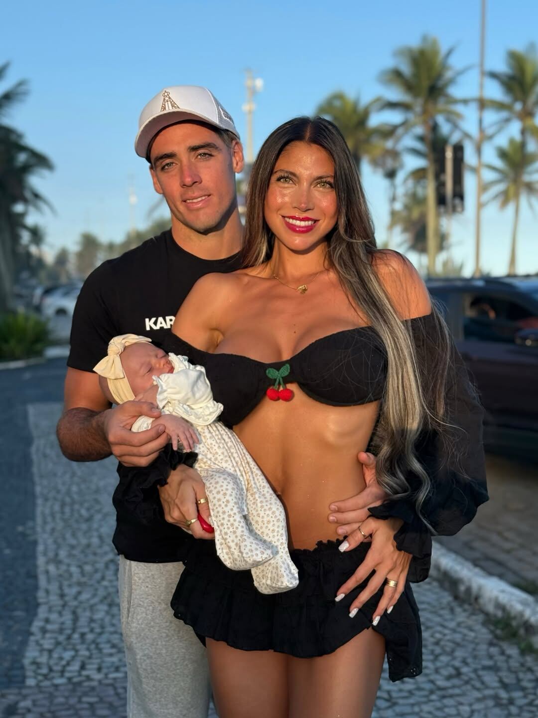 El futbolista Claudio Spinelli y Cielo López posan al aire libre junto a su bebé recién nacido.
